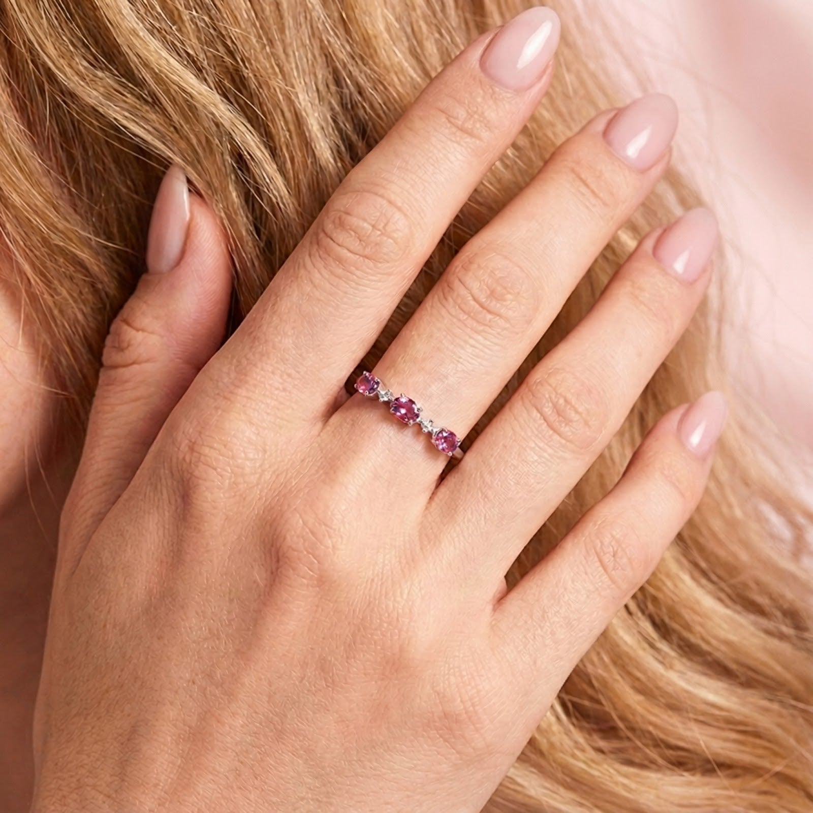 Scale view of the Aurelissa S925 sterling silver bypass ring with pink tourmaline stones on a woman's hand.