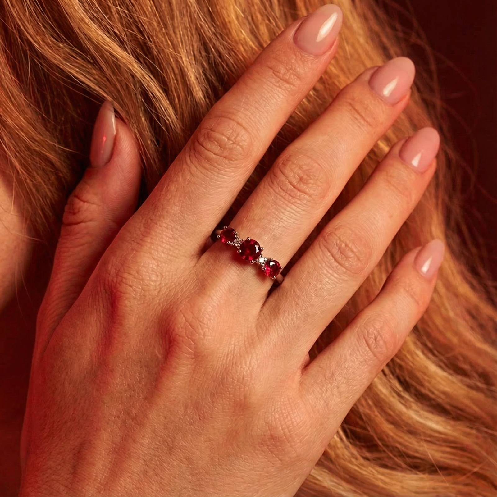 Close-up of the Thalaraea sterling silver ring with three red simulated rubies on a woman's finger.