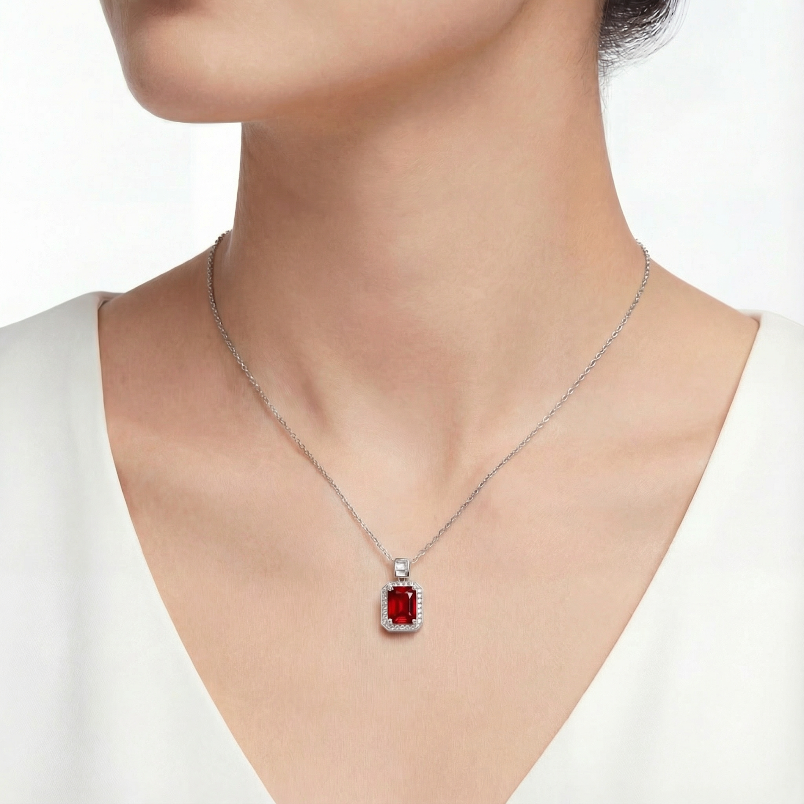 Model wearing the Aurelise emerald cut simulated ruby necklace in S925 sterling silver.