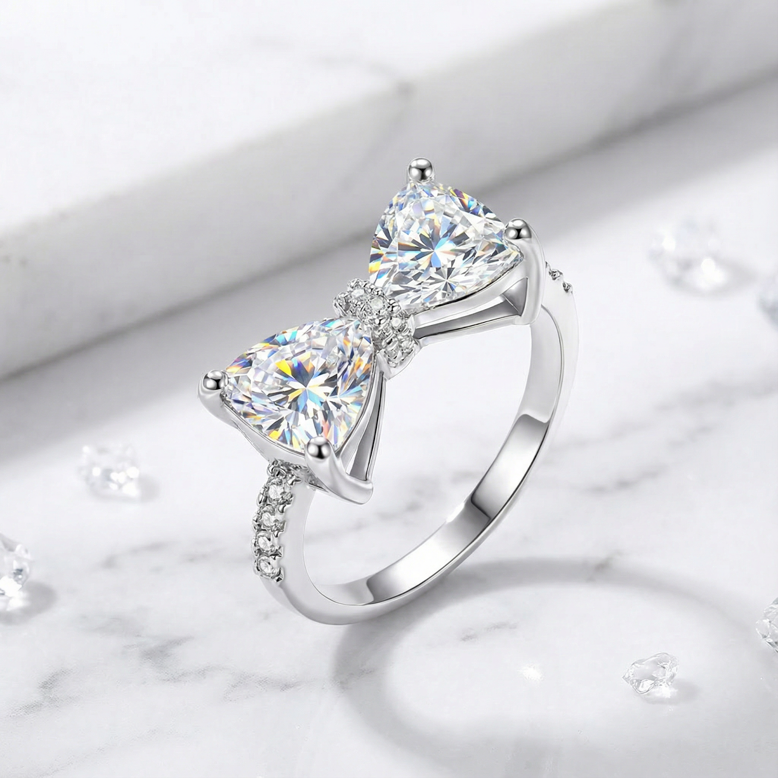 Trillion-cut simulated diamond bow ring in S925 sterling silver on a white marble surface.