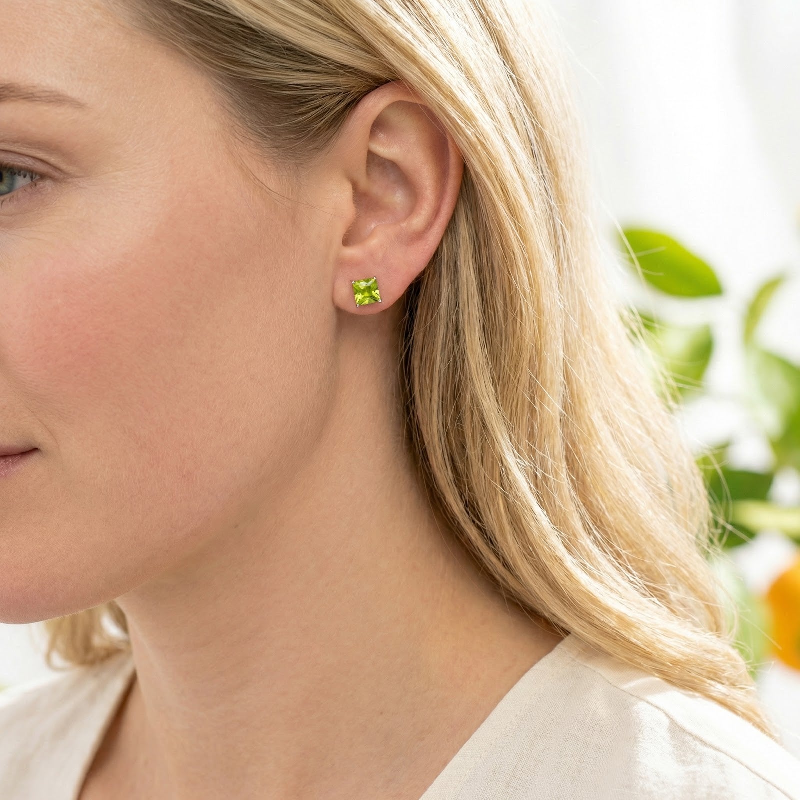 Side view of a model wearing a vibrant square cut simulated peridot earring in 18K rose gold vermeil.