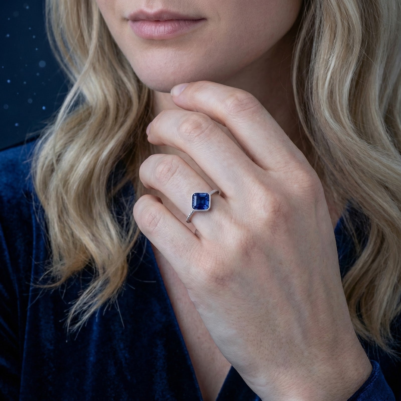 Woman wearing the Zenise blue sapphire sterling silver adjustable ring with a blue velvet dress.