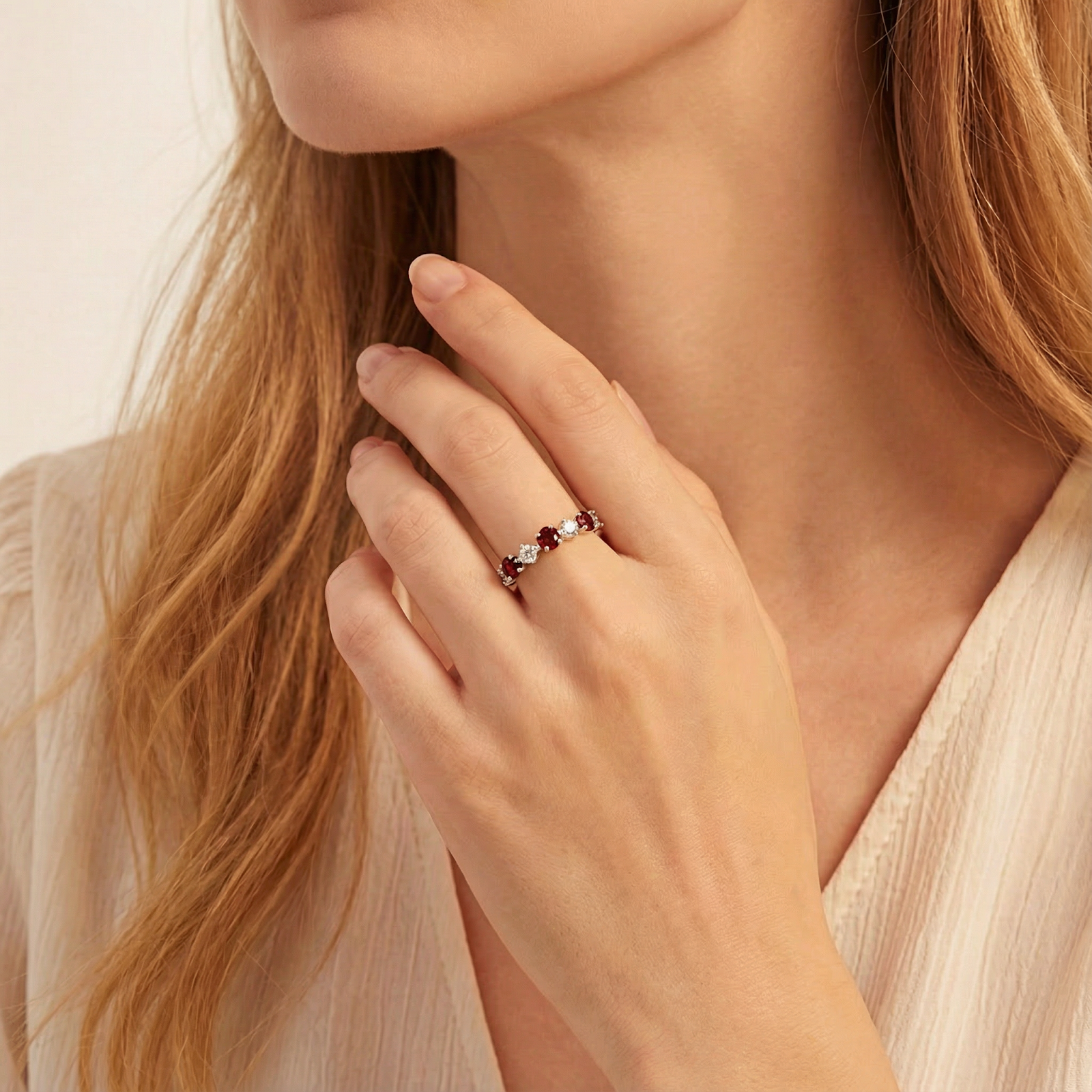Woman wearing the Aeliana sterling silver eternity ring with alternating red and clear round cut stones.