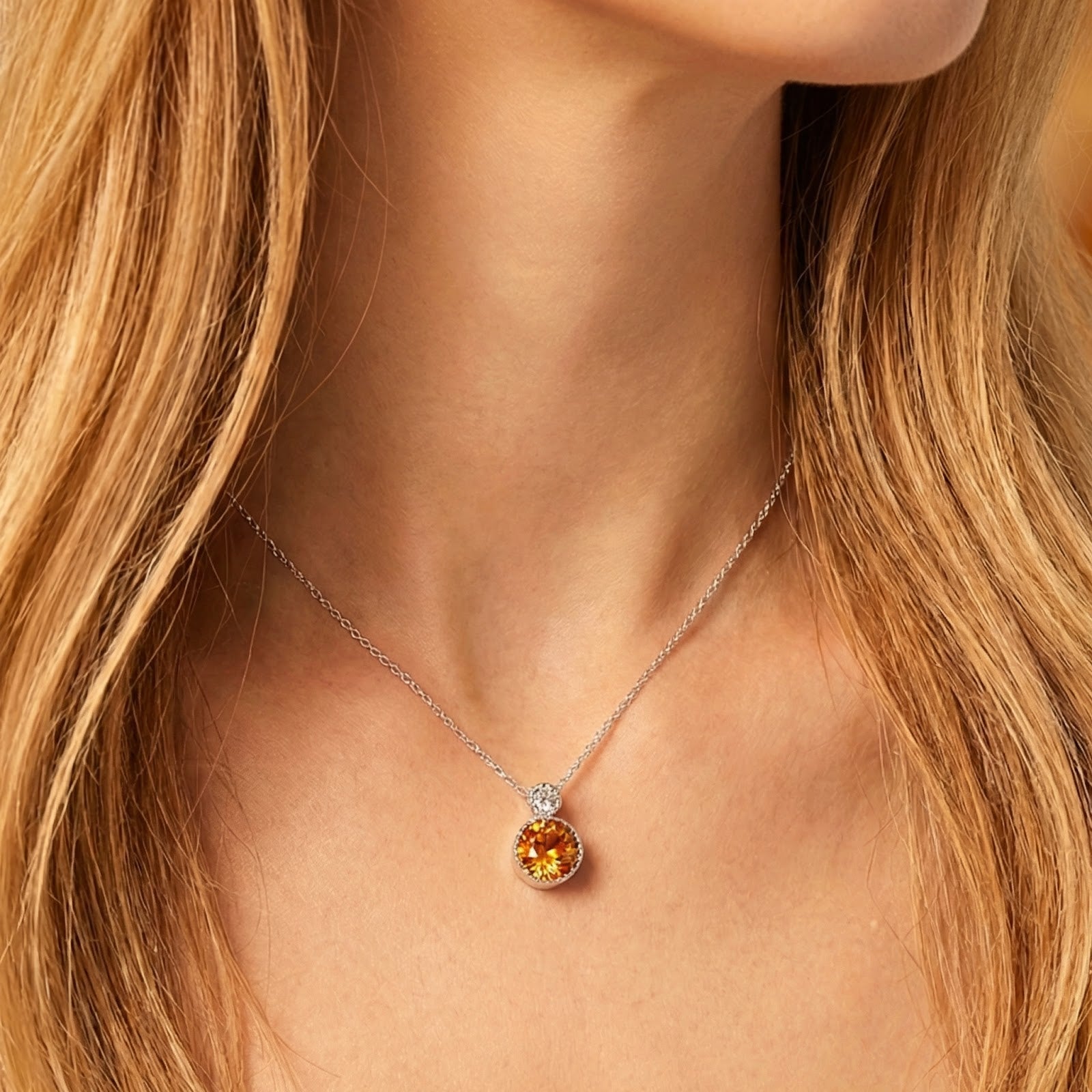 Sterling silver necklace with a round honey-colored simulated topaz stone worn by a model.