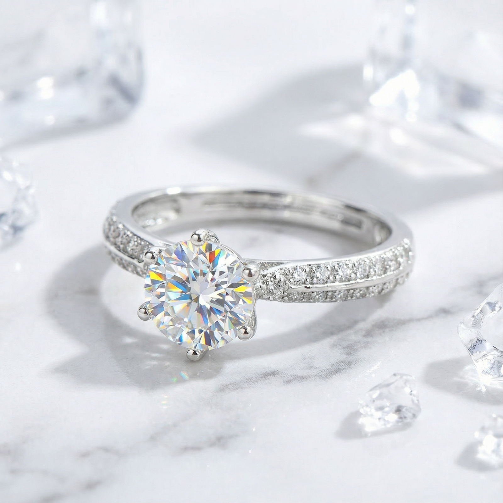 Macro view of a round simulated diamond solitaire ring in sterling silver showing the pavé band details.