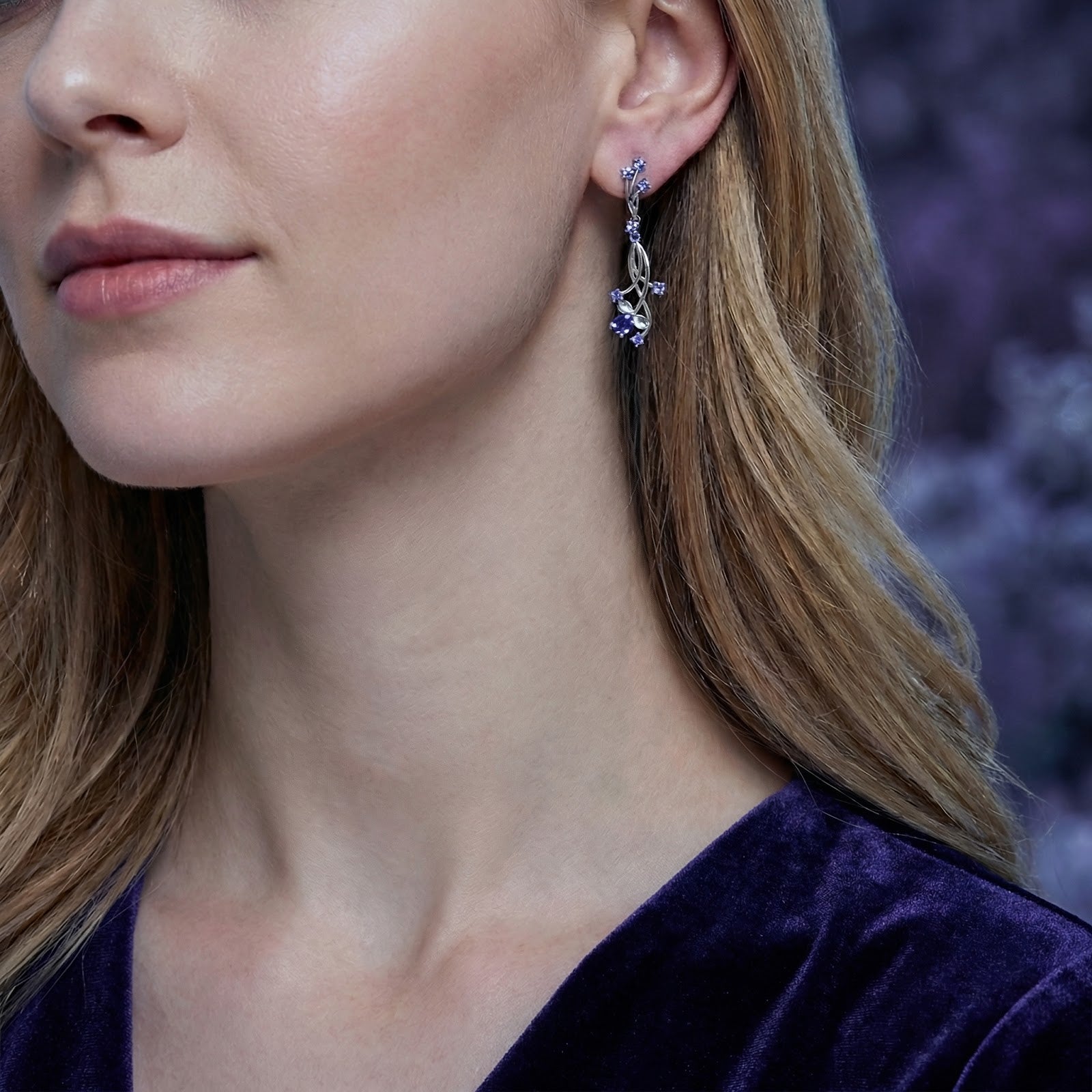 Model wearing the Thalinea sterling silver drop earrings featuring blue-violet simulated tanzanite stones.