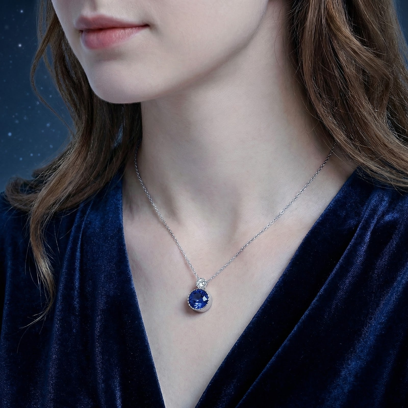 Model wearing the Caelis sterling silver necklace with a round simulated sapphire pendant.