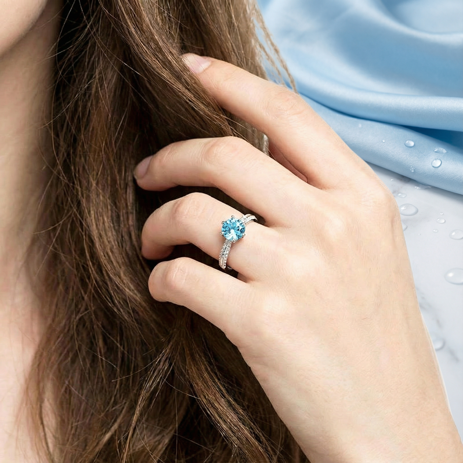 Model wearing the Adeline solitaire ring in sterling silver with a round simulated aquamarine stone.