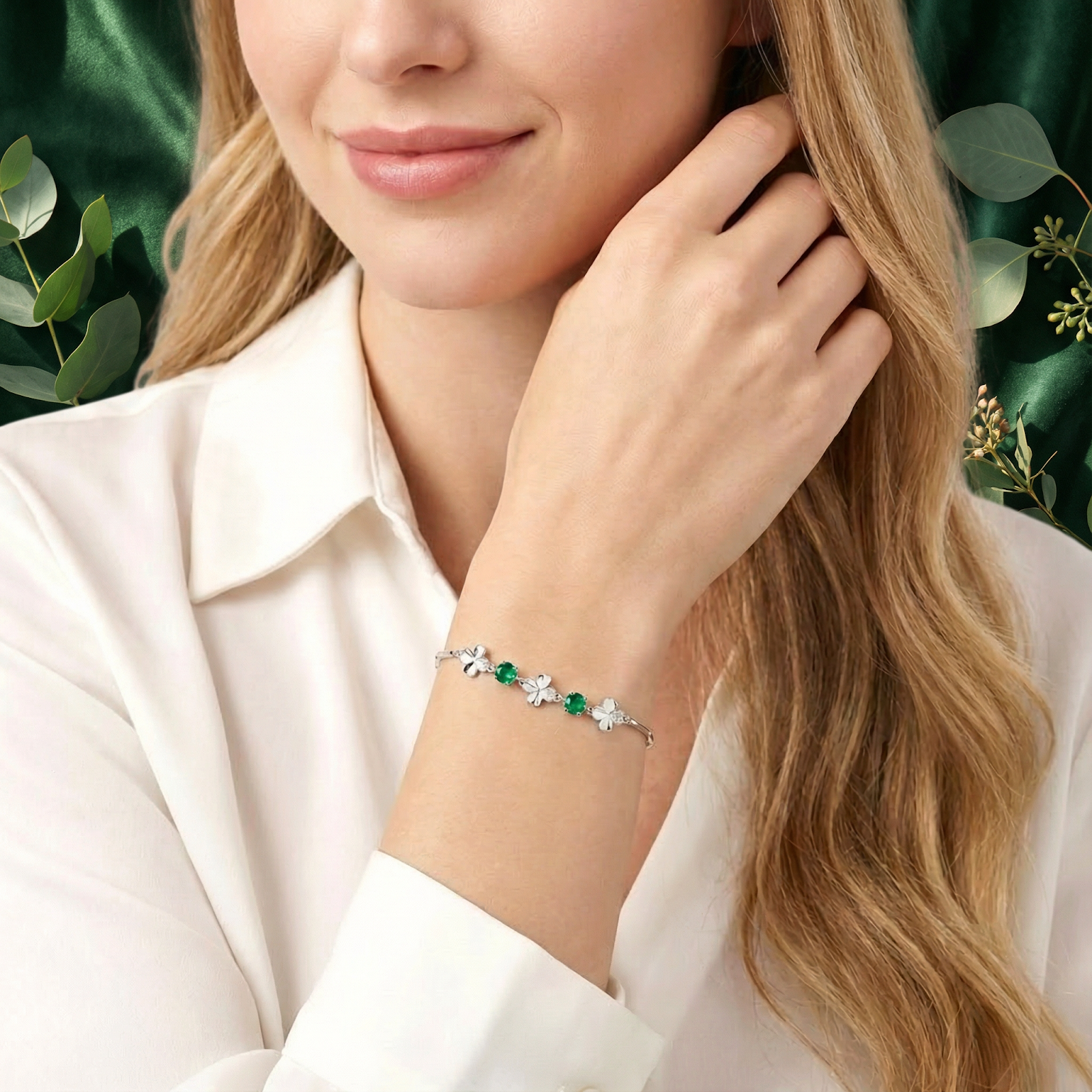 Woman wearing the sterling silver Aurelise clover bracelet with green simulated emeralds on her wrist.