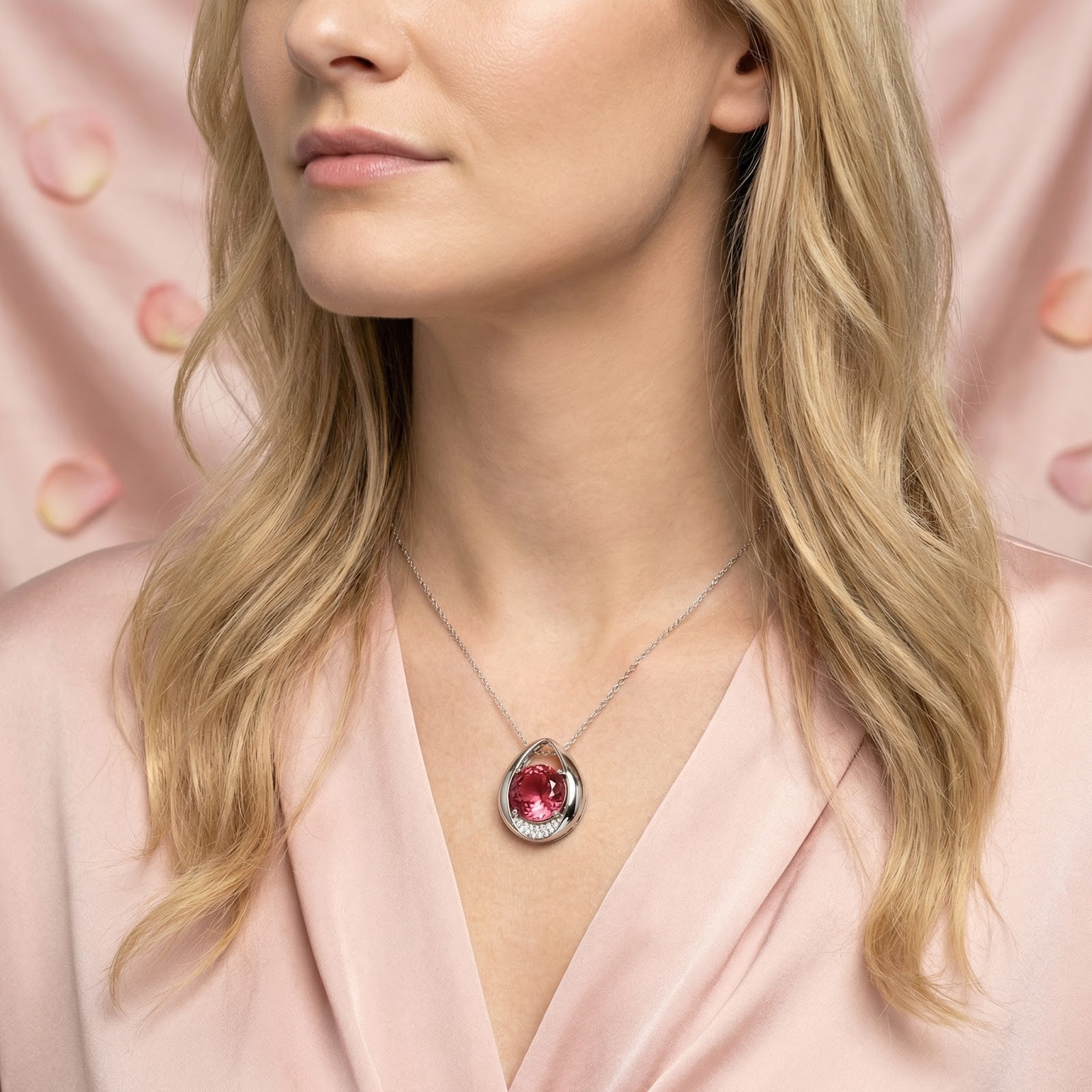 Blonde model wearing the Valisara teardrop necklace with a round simulated pink tourmaline in S925 sterling silver.