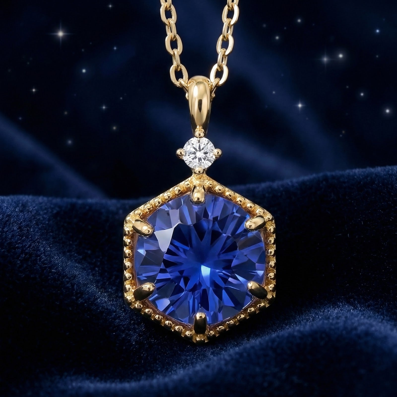 Frontal macro view of the royal blue hexagon simulated sapphire necklace in 18K gold vermeil on velvet.