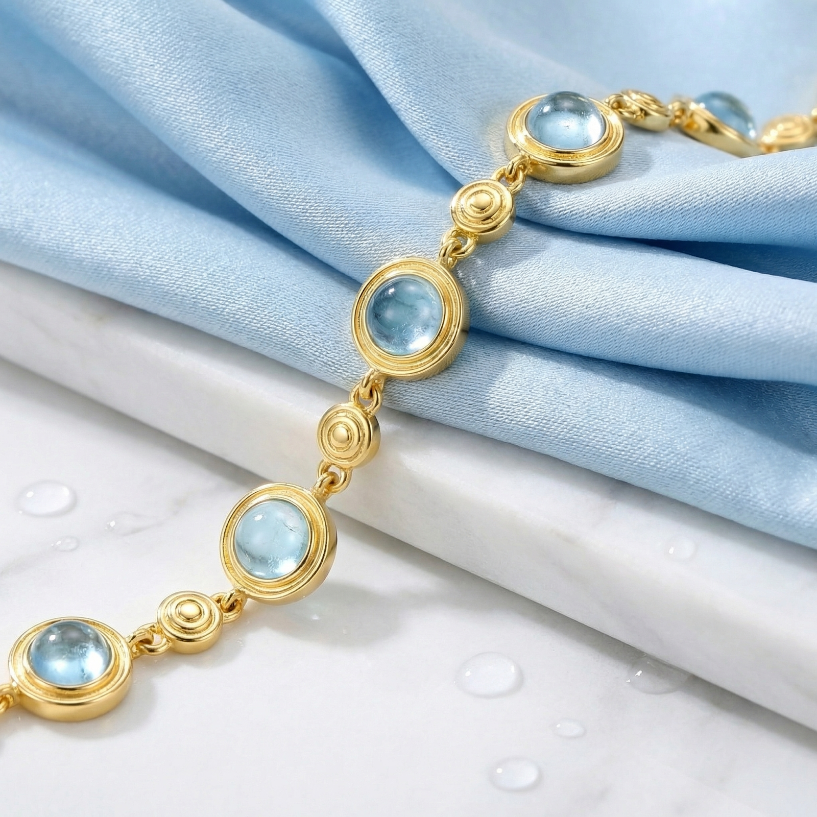 Close-up of the round simulated aquamarine stations on the 18K gold vermeil Marisol bracelet.