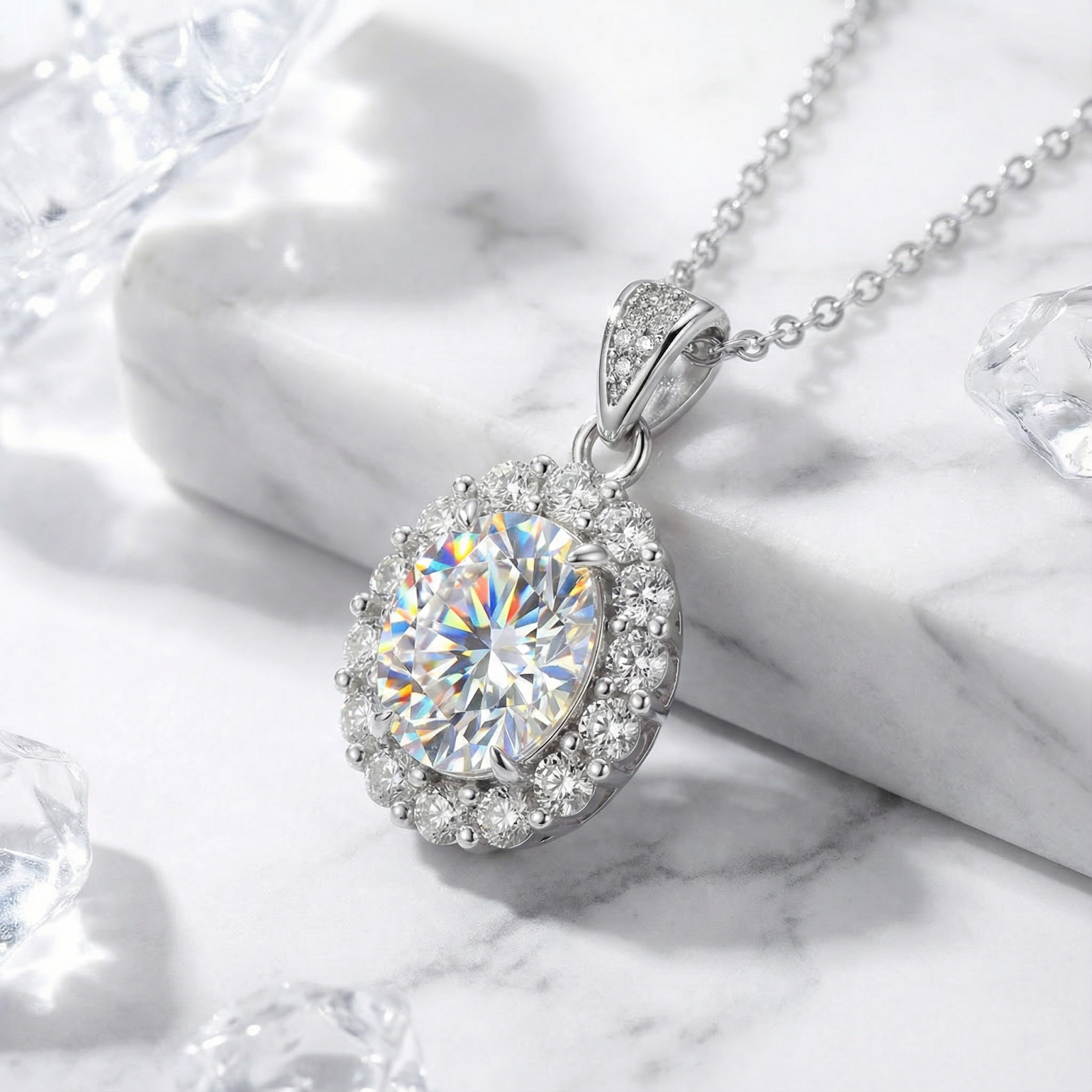 Angled view of the Elianthe oval halo simulated diamond pendant in silver on a marble background.