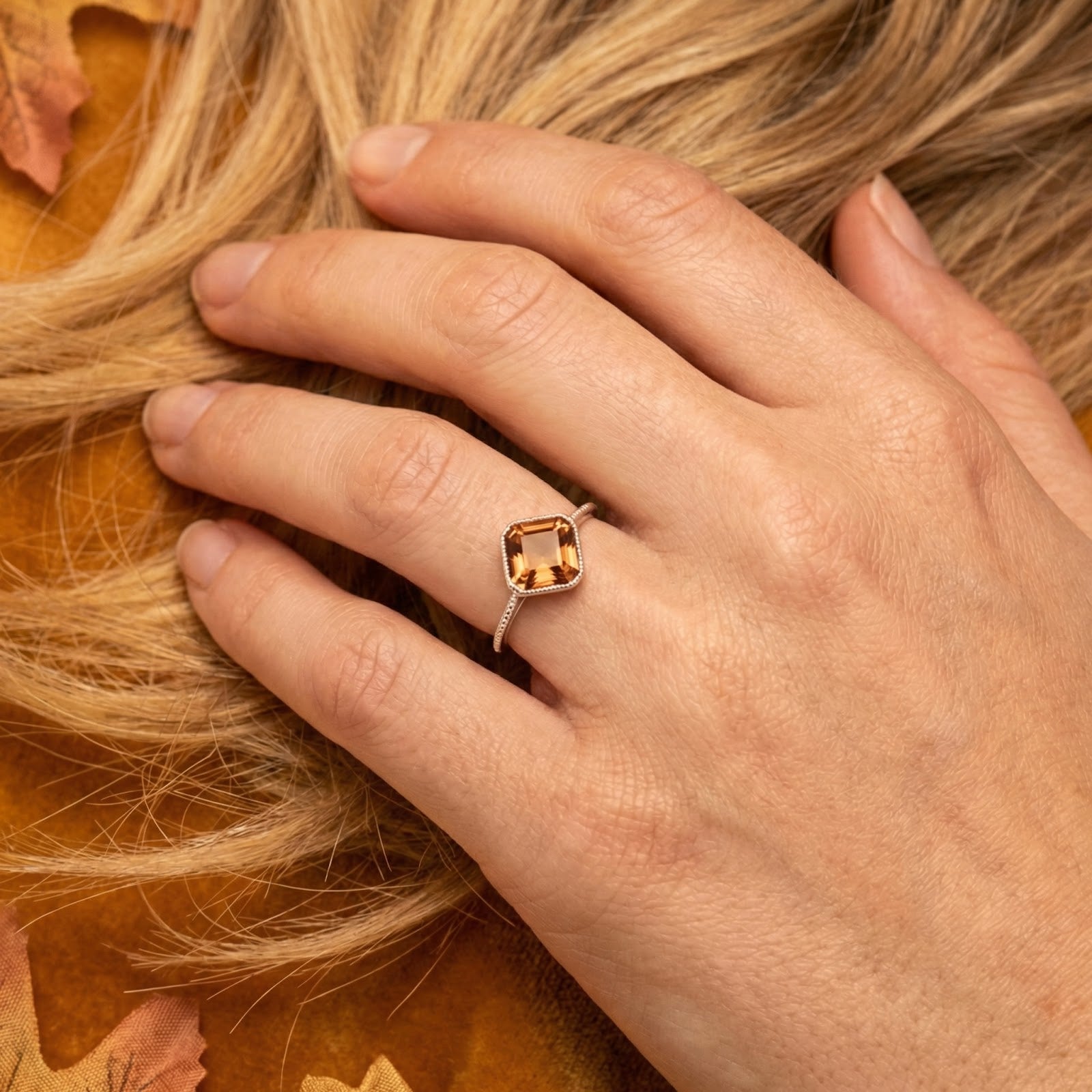 Woman's hand wearing the Elianara cushion-cut honey gold simulated topaz ring in S925 sterling silver.