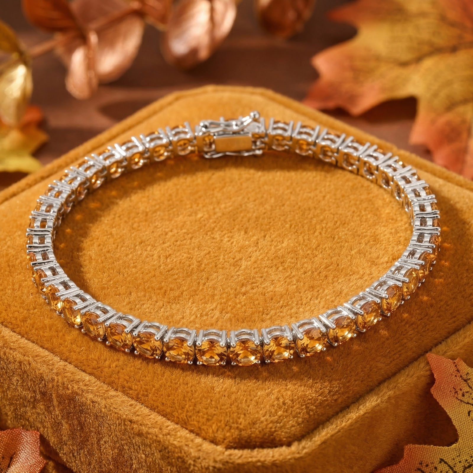 Stainless steel tennis bracelet with round simulated honey topaz November birthstones on an autumn background.