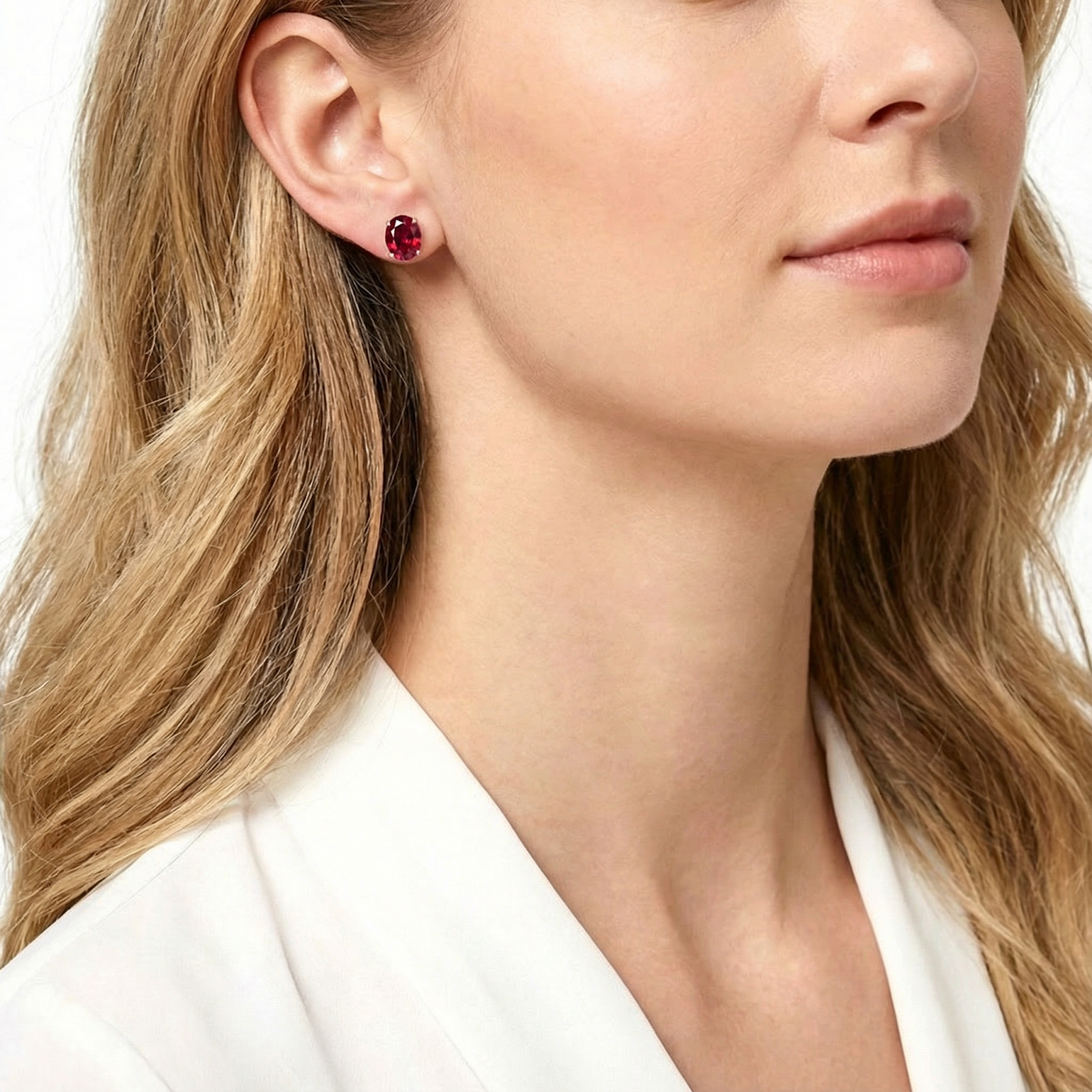 Side view of a model wearing an oval-cut simulated ruby stud earring in sterling silver.