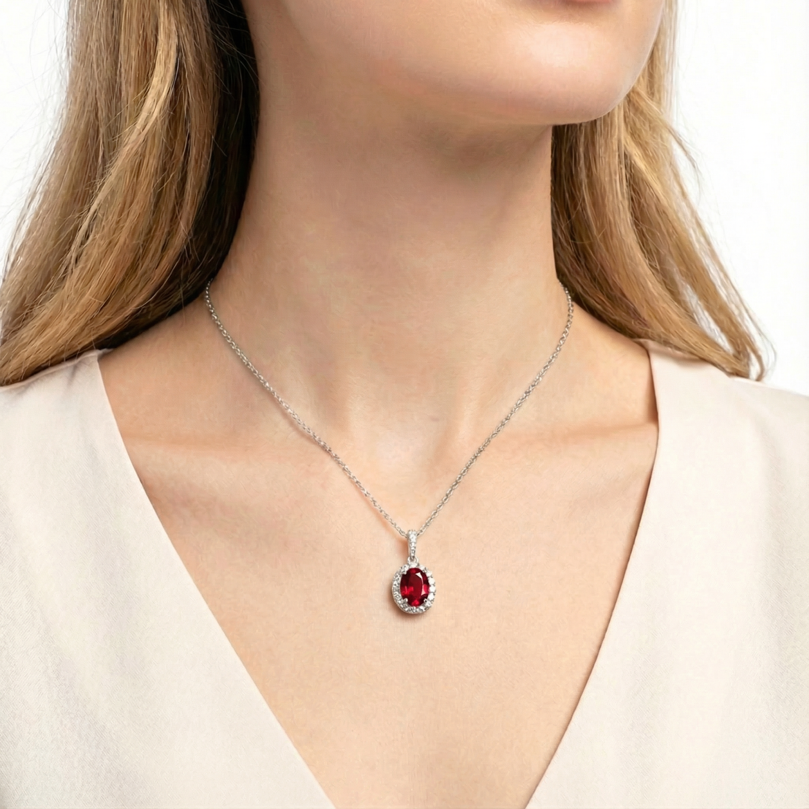 The Mirelle Halo simulated ruby necklace in sterling silver worn by a woman in a white top.