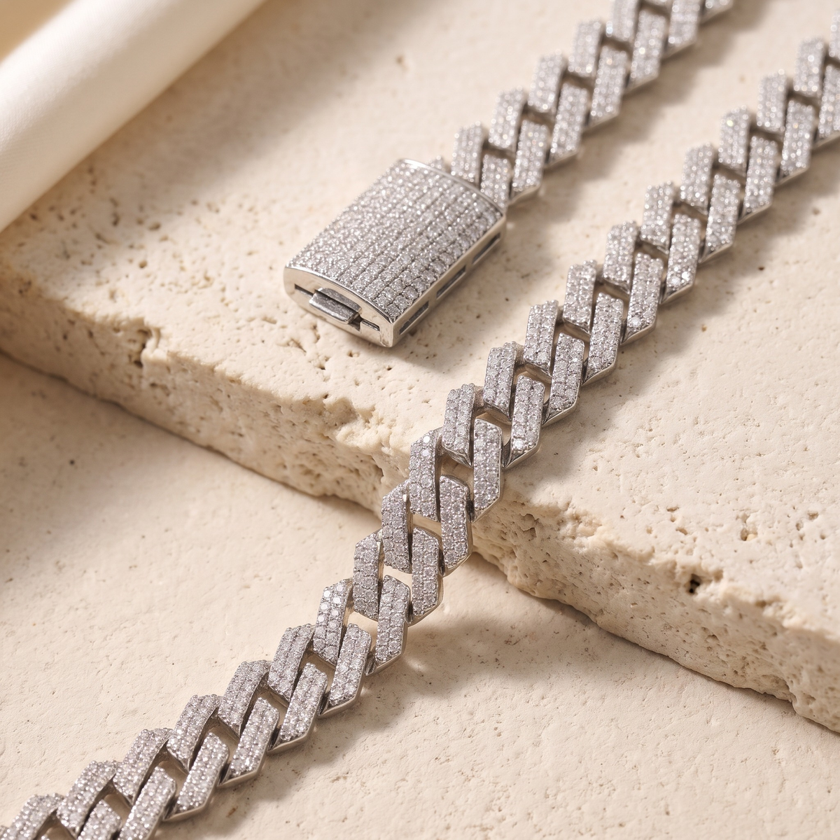 Silver iced moissanite Cuban links and rectangular box clasp, angled closeup.