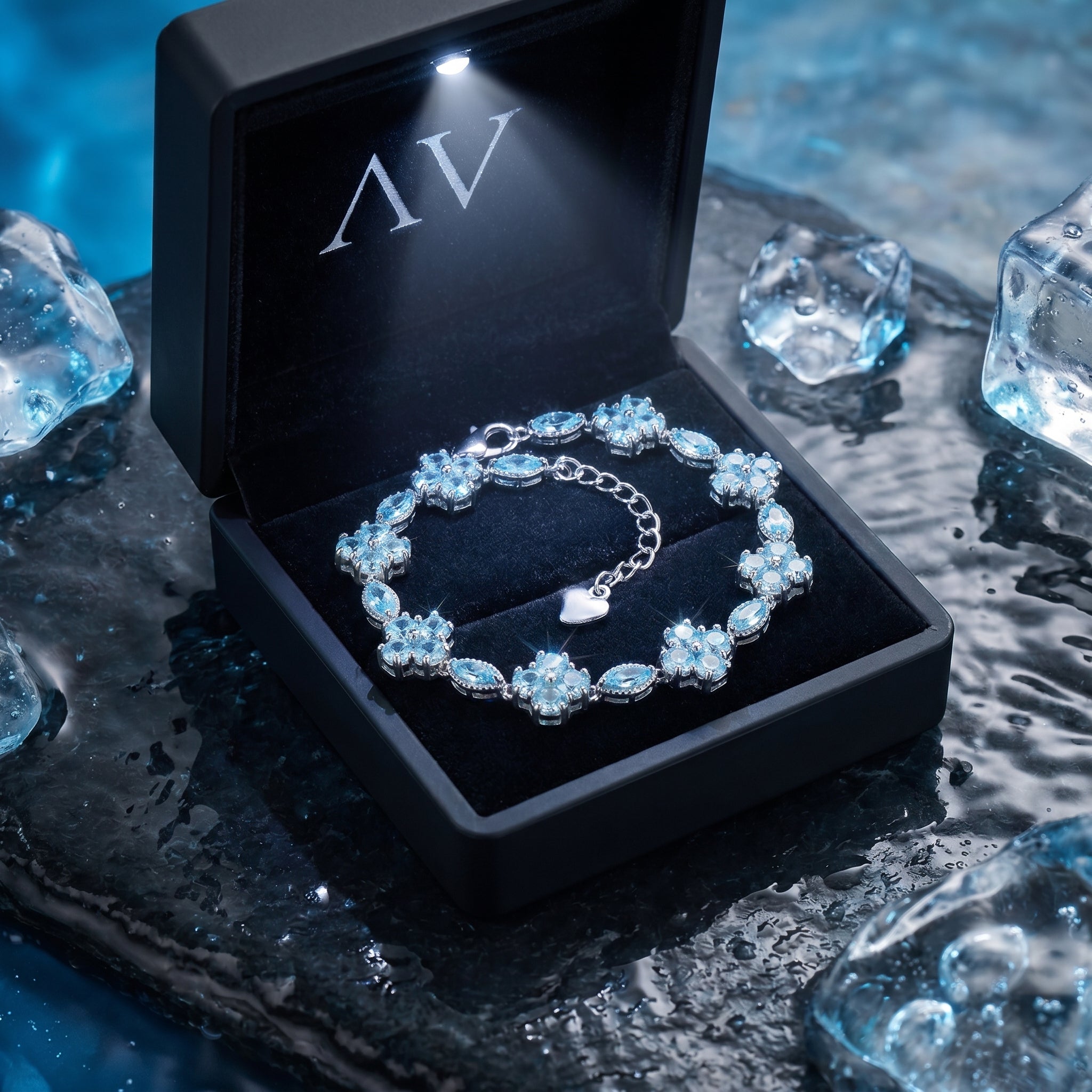 Aquarina aquamarine station bracelet in a black LED-lit gift box on a wet stone background.