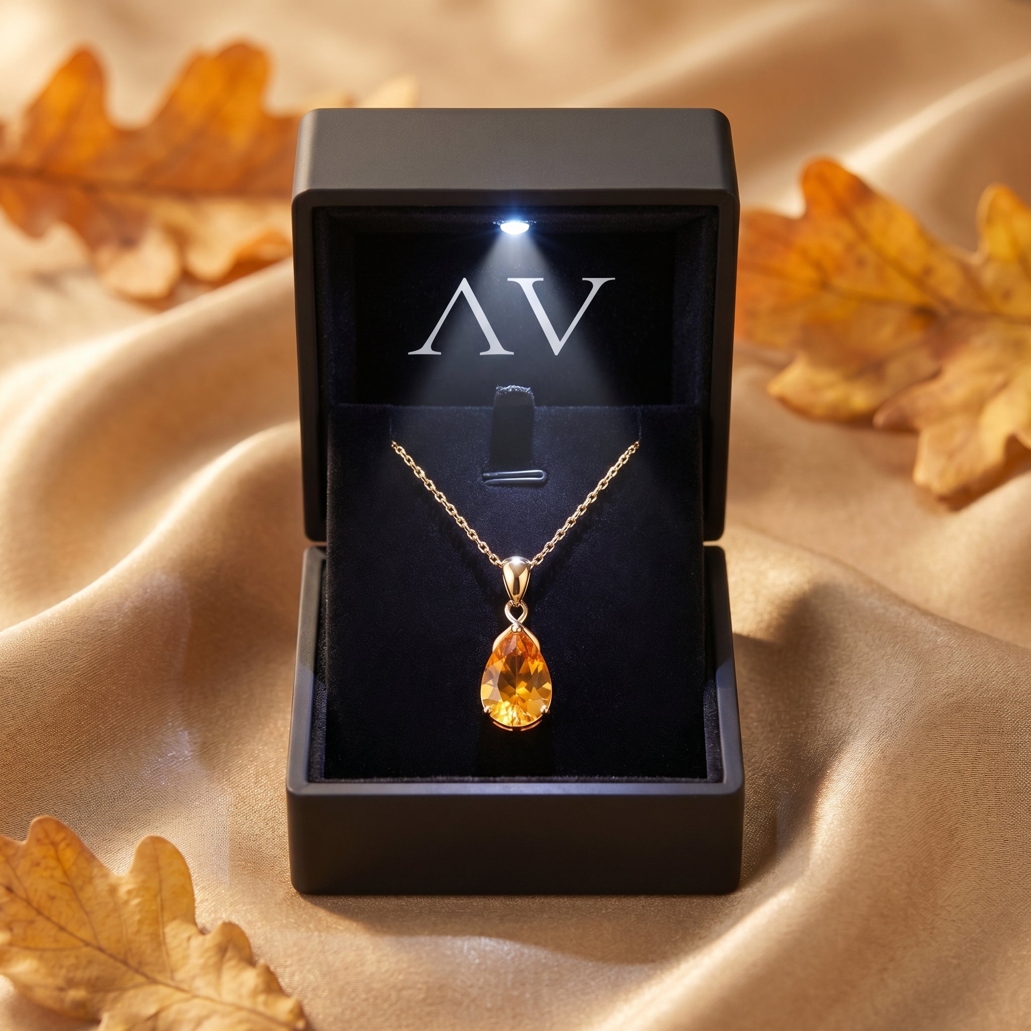 Pear cut citrine necklace in 18K yellow gold inside a black LED-lit jewelry presentation box.