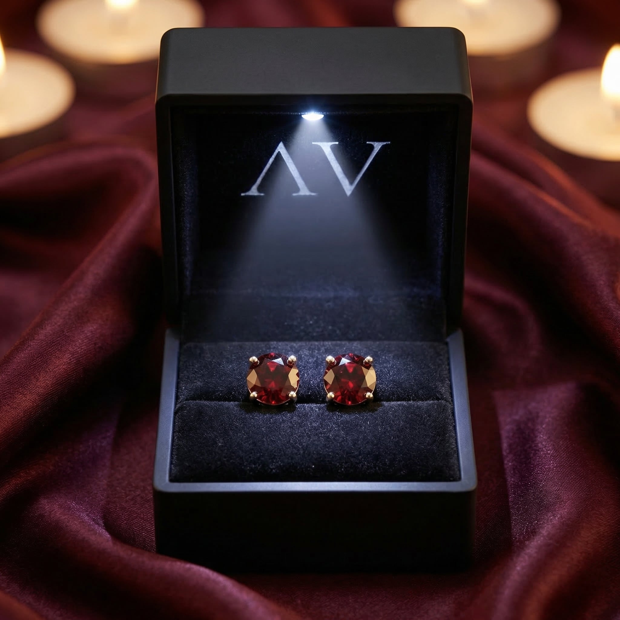 18K white gold garnet stud earrings displayed in a premium black LED-lighted gift box with AV branding.