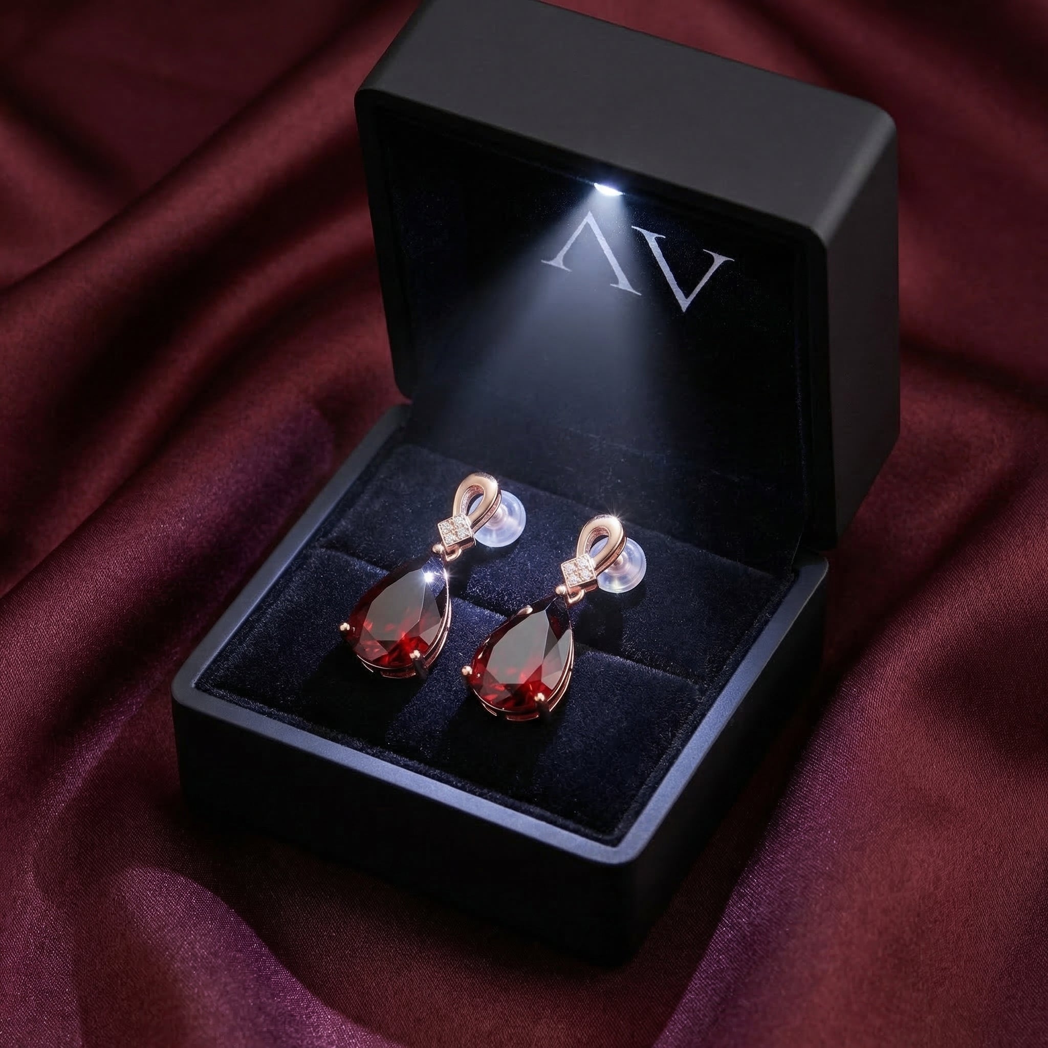 18K rose gold pear-cut garnet drop earrings presented in a premium black lighted jewelry gift box.