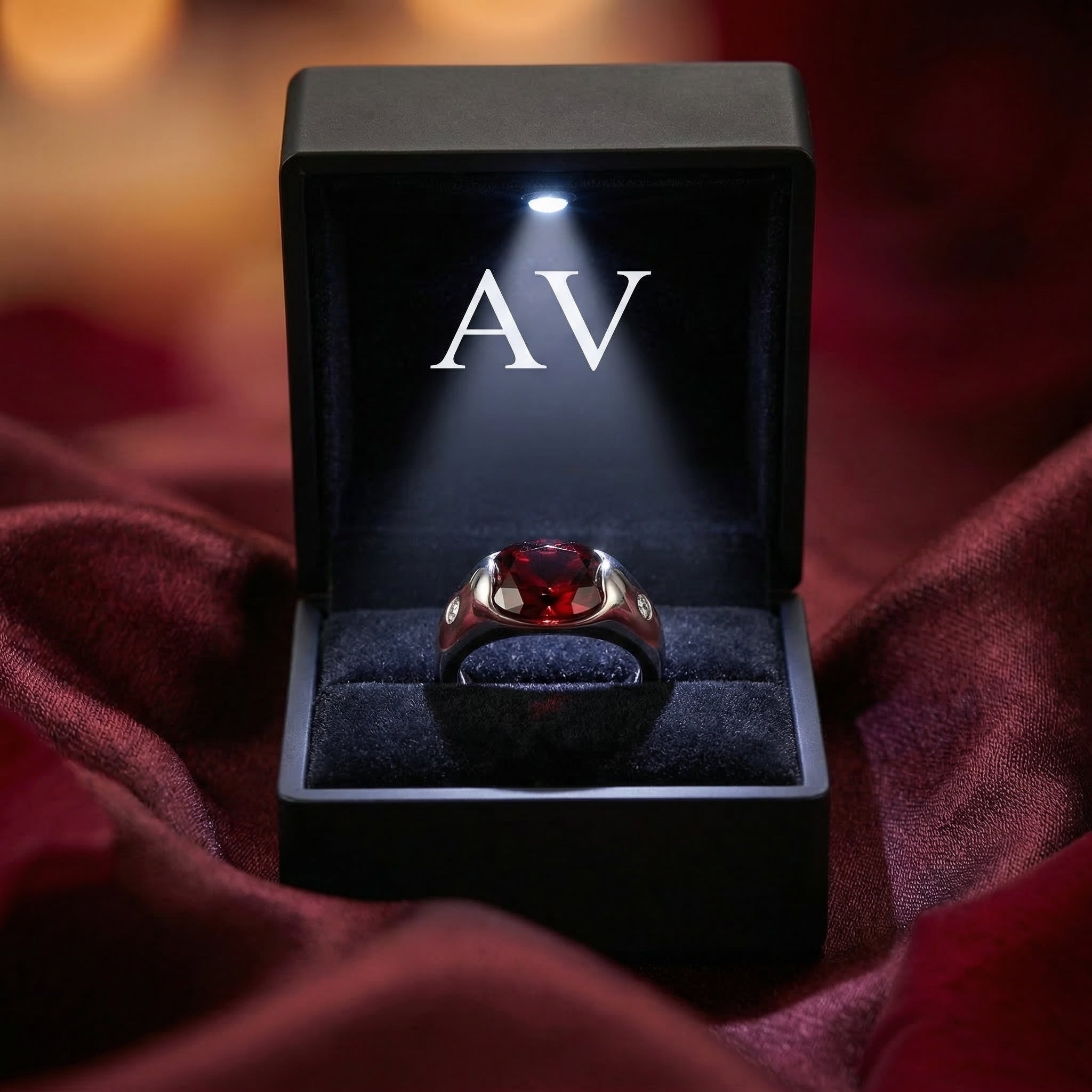Oval garnet sterling silver ring displayed in a premium lighted black jewelry box.