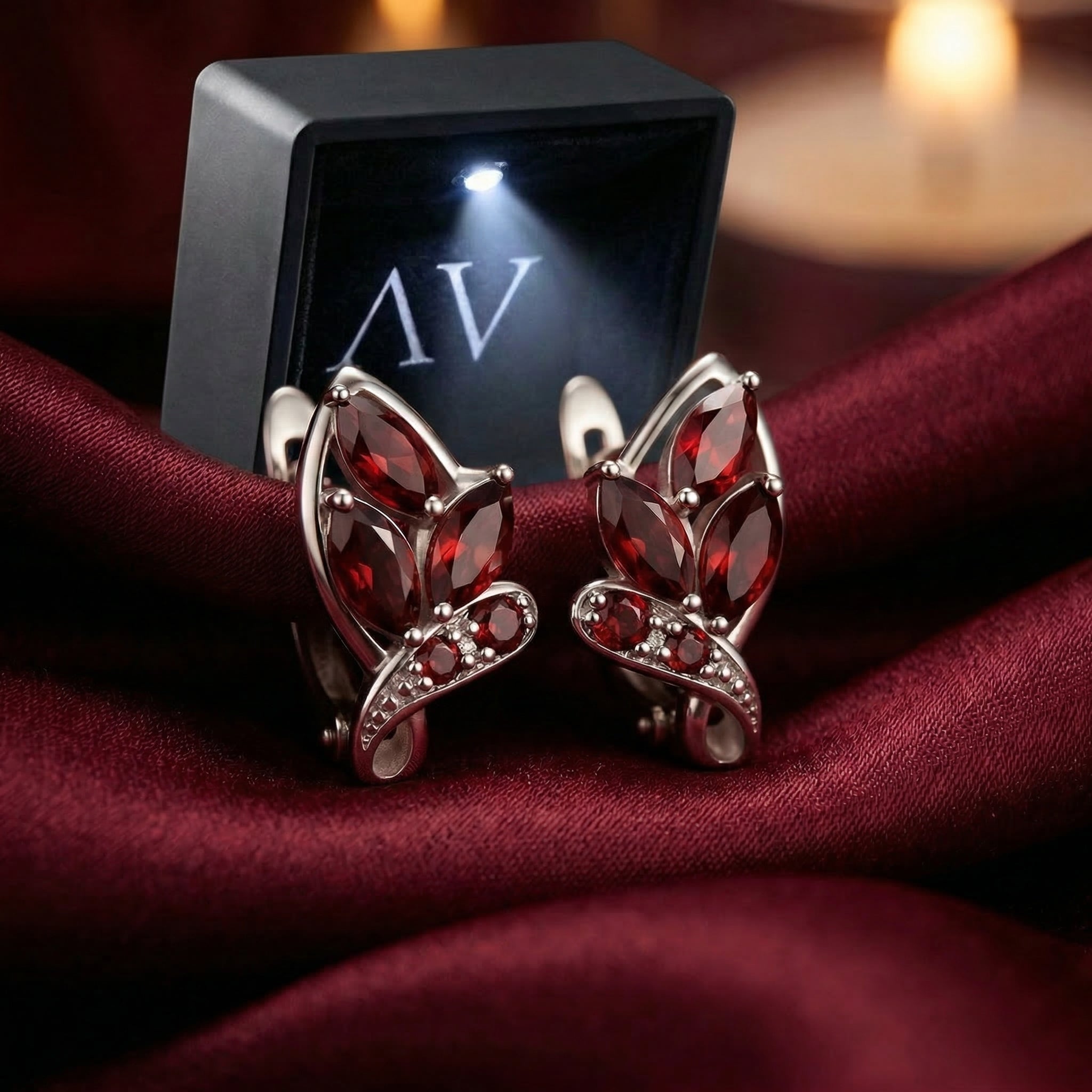 Natural garnet drop earrings in sterling silver presented with a black LED-lit jewelry gift box.