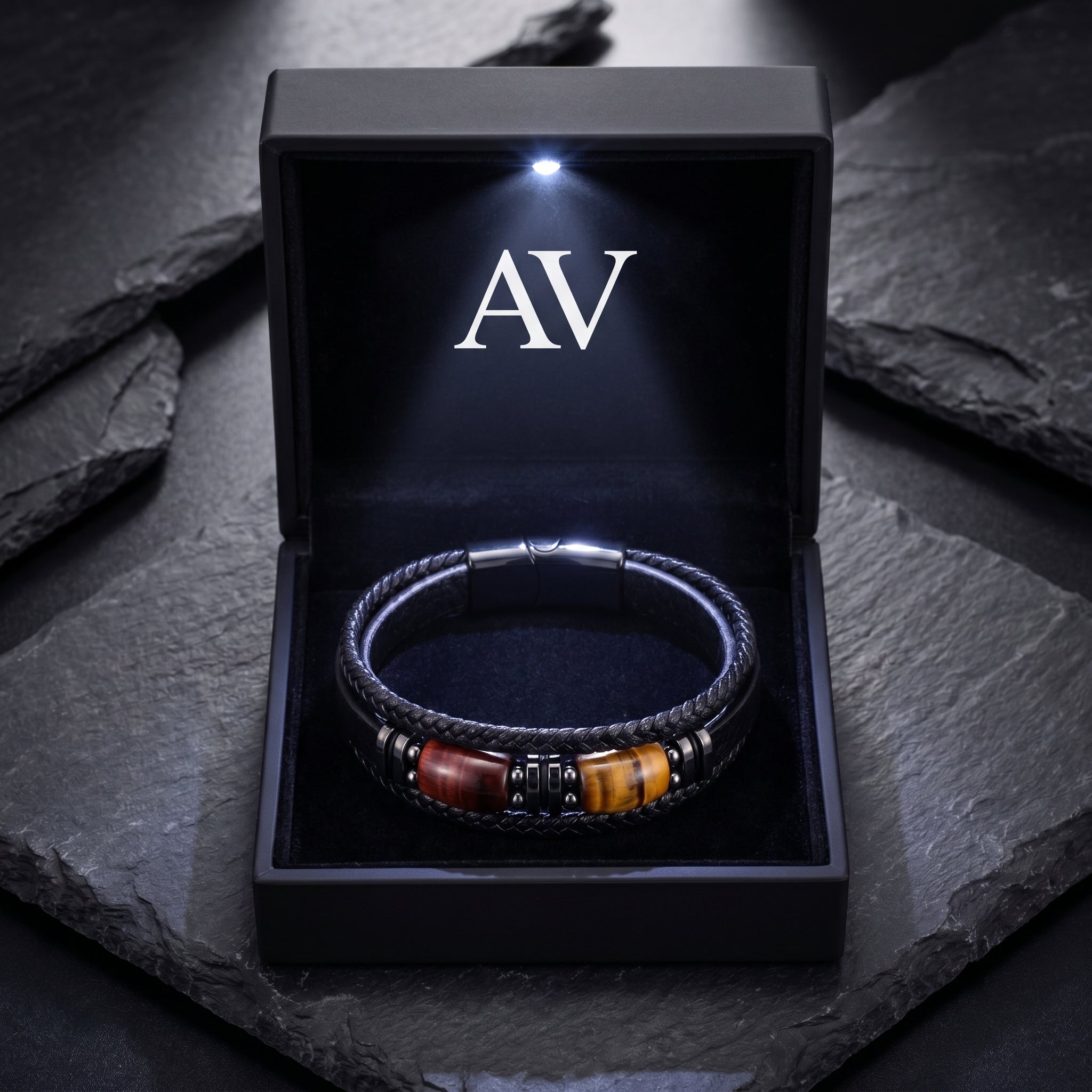 Black braided leather and steel bracelet with tiger's eye beads in a black LED-lit jewelry presentation box.