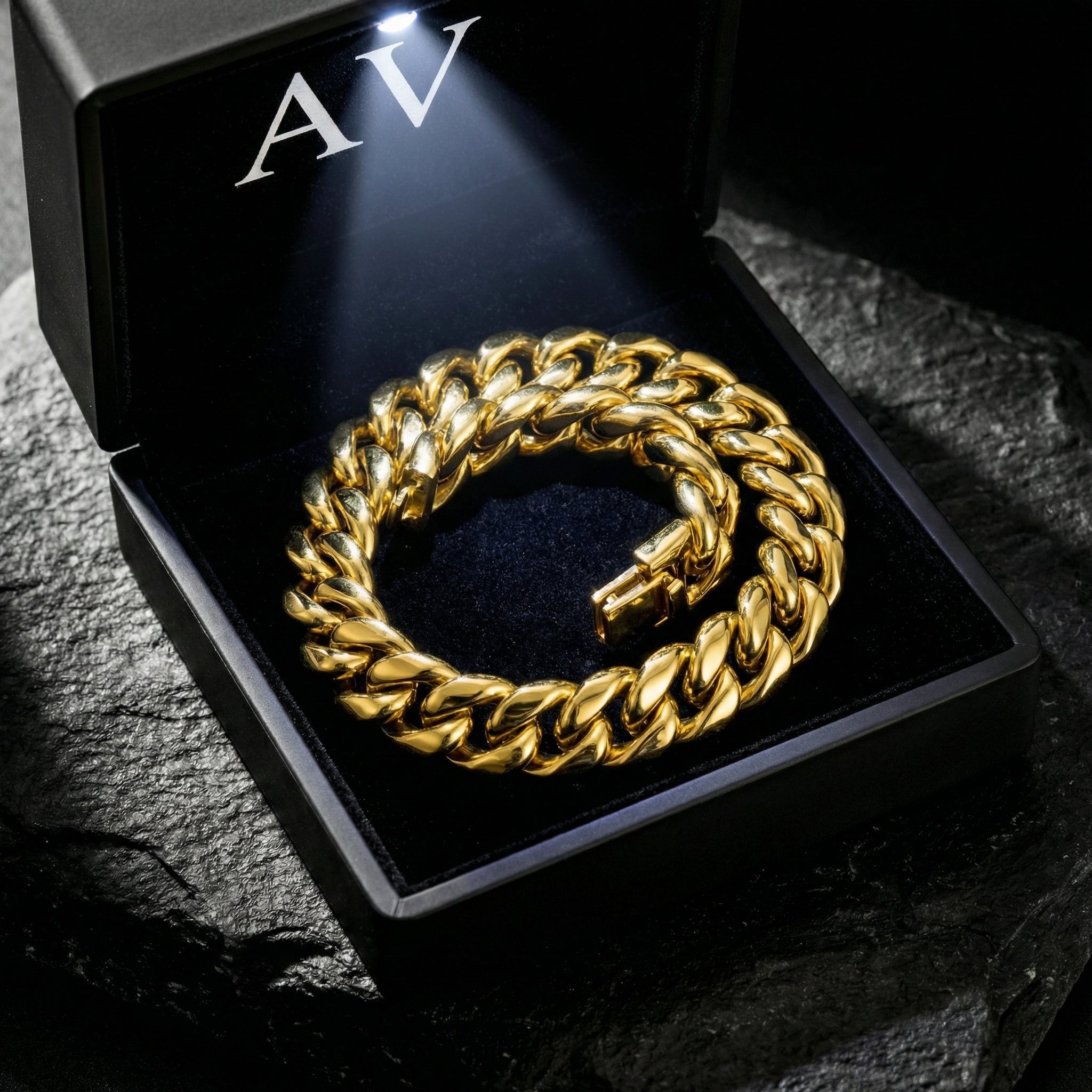 Gold stainless steel Cuban link bracelet inside an illuminated black presentation box.