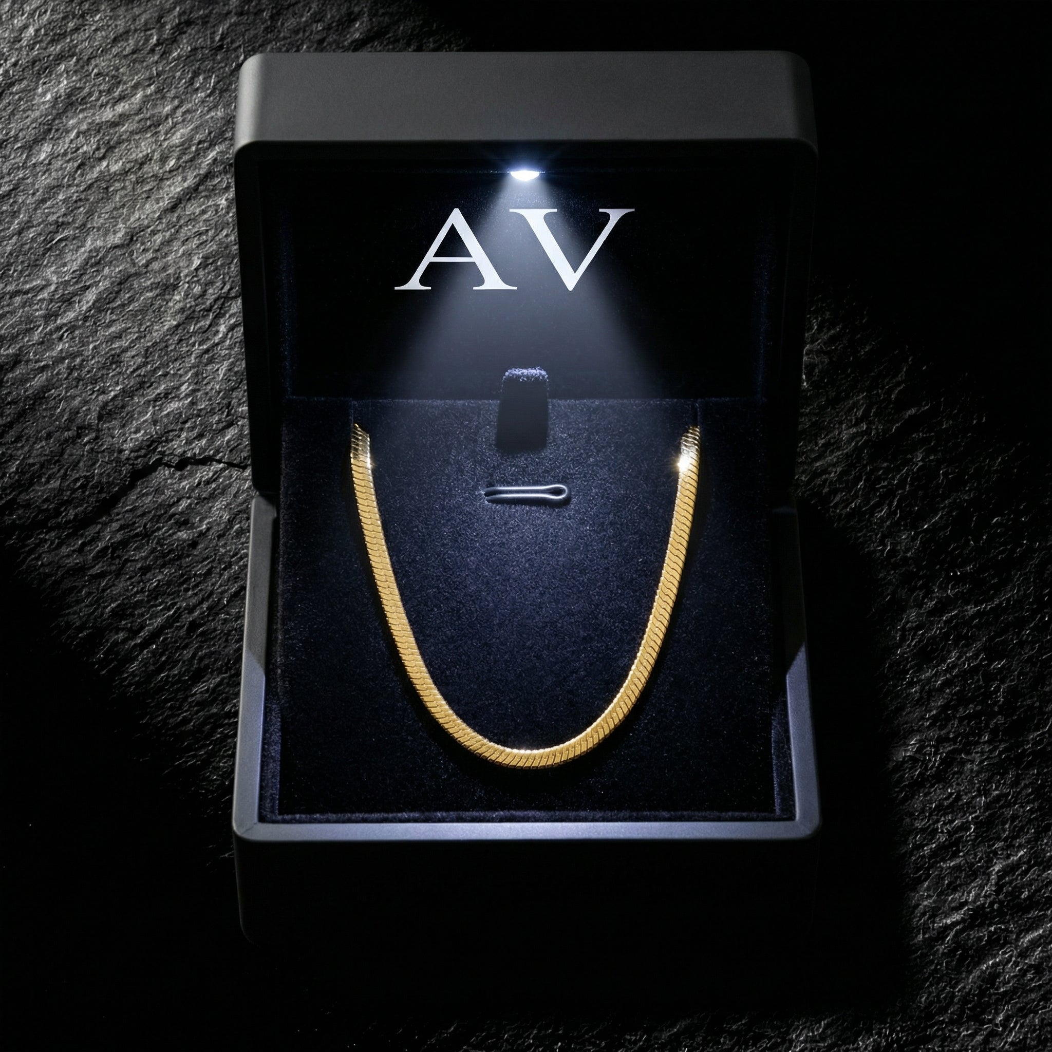 Gold stainless steel Square Dance Chain inside a black LED-lit jewelry box with AV branding.