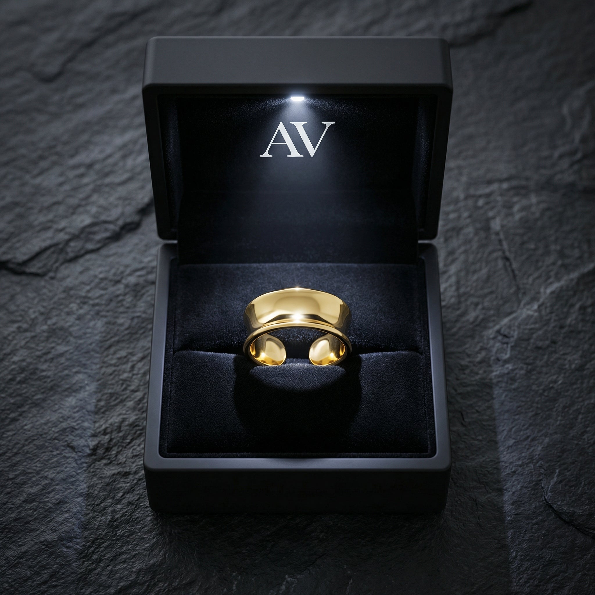 Gold stainless steel Origin Flow ring presented in a black LED-lit jewelry box with the AV logo.