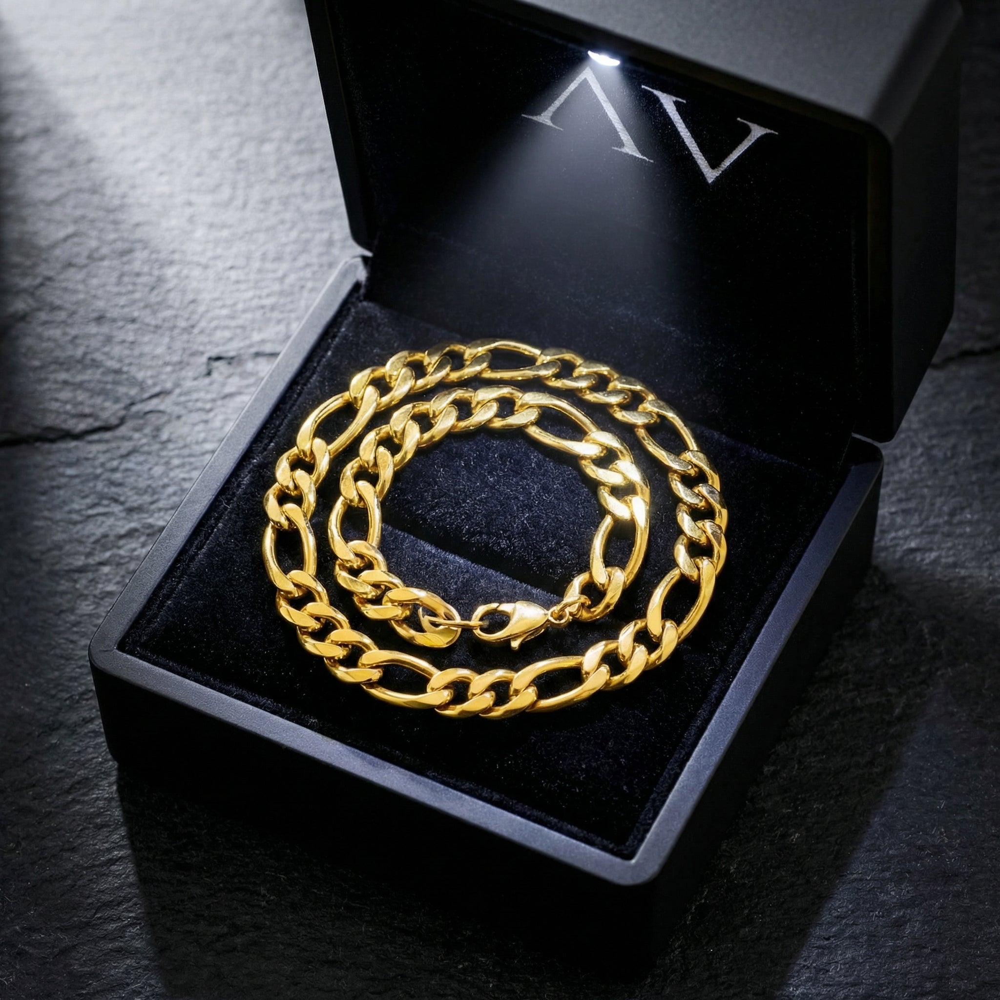 Gold Figaro chain and bracelet set presented in a premium black LED-lit jewelry gift box.