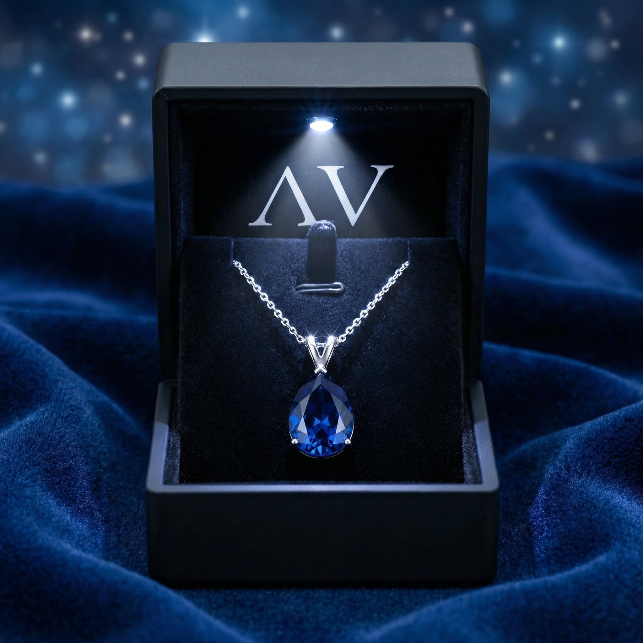 Sterling silver pear cut simulated sapphire necklace presented in a black LED-lit jewelry box.