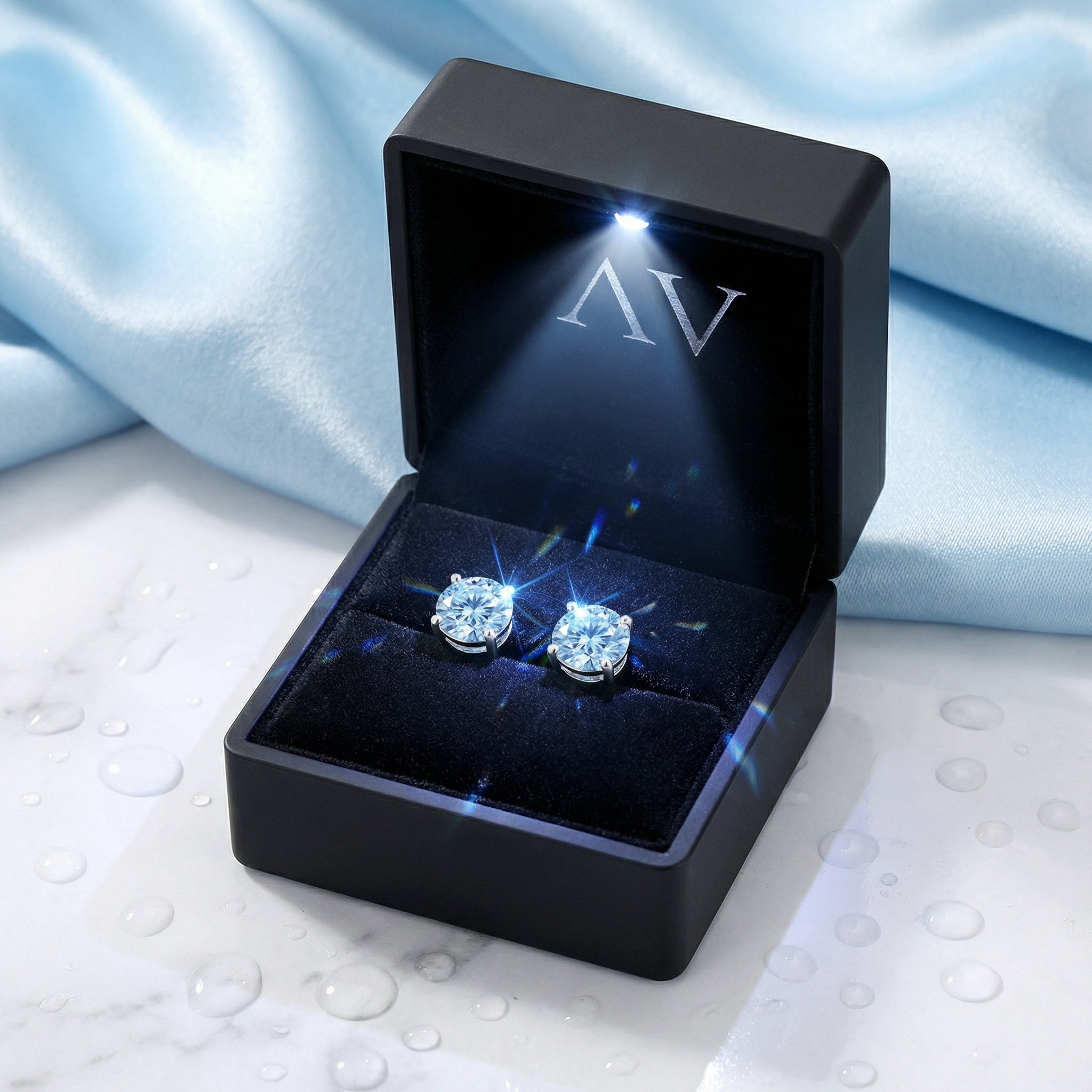 Round cut simulated aquamarine sterling silver stud earrings inside a black LED-lit jewelry gift box.