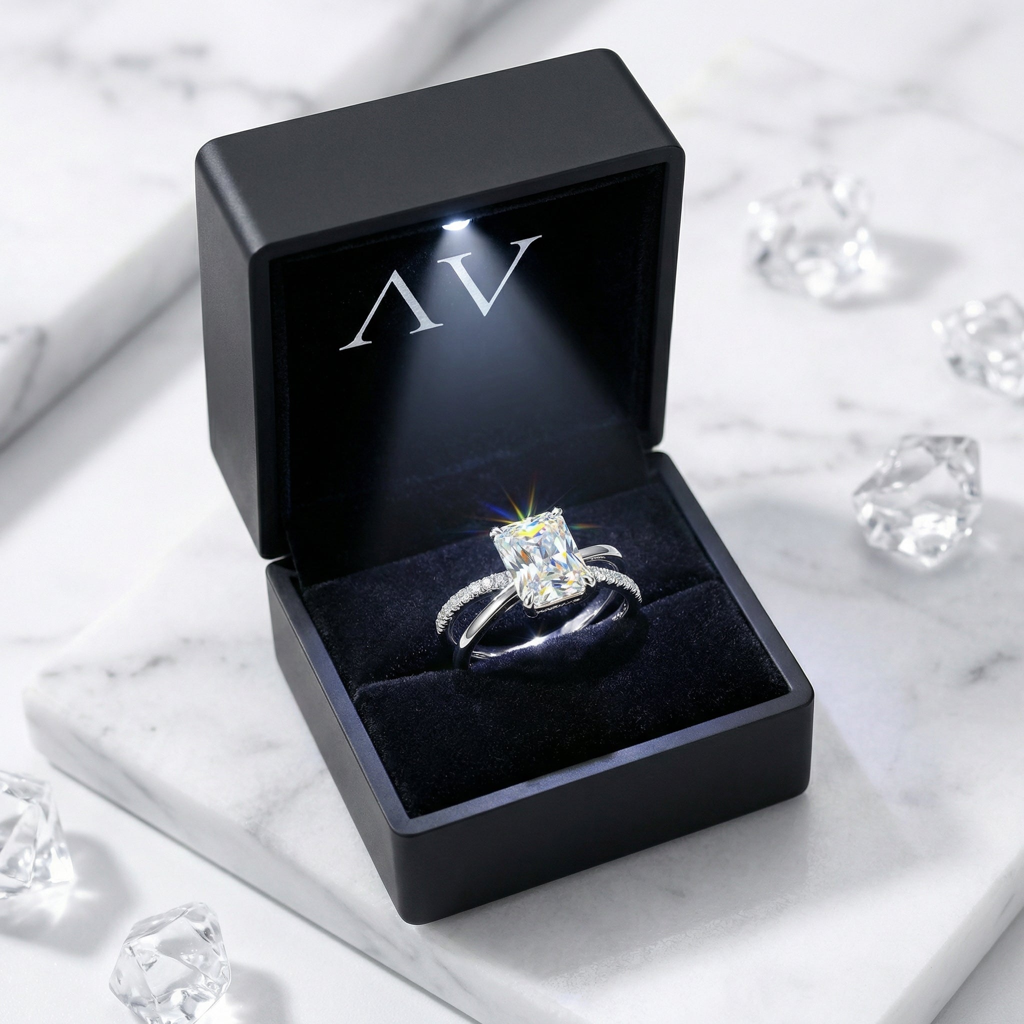 The Calysia radiant cut simulated diamond ring in S925 sterling silver inside a lighted black velvet gift box.