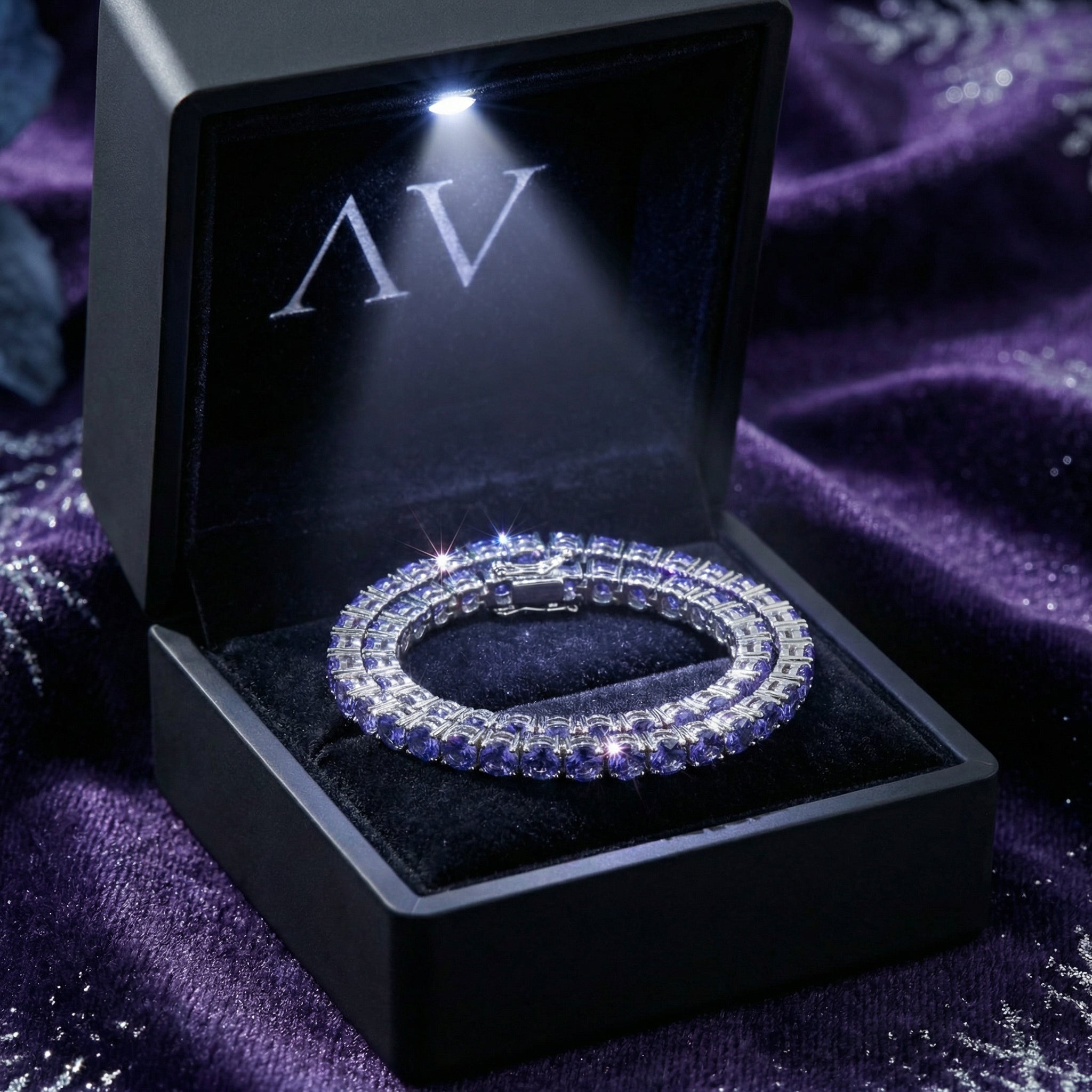 Stainless steel simulated tanzanite tennis bracelet presented in a black LED-lit jewelry gift box.