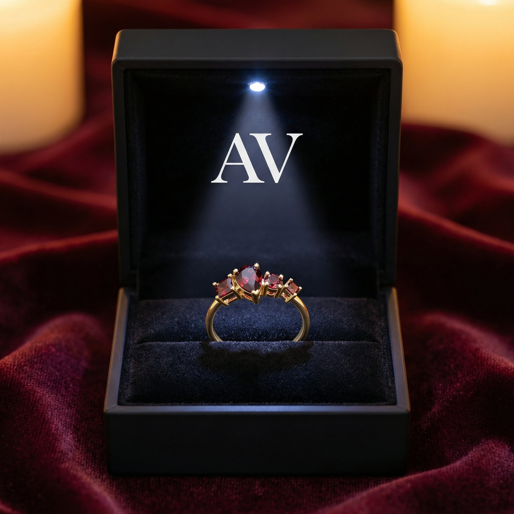 The Lunette 18K gold vermeil garnet ring in a black lighted gift box with AV branding on red velvet.