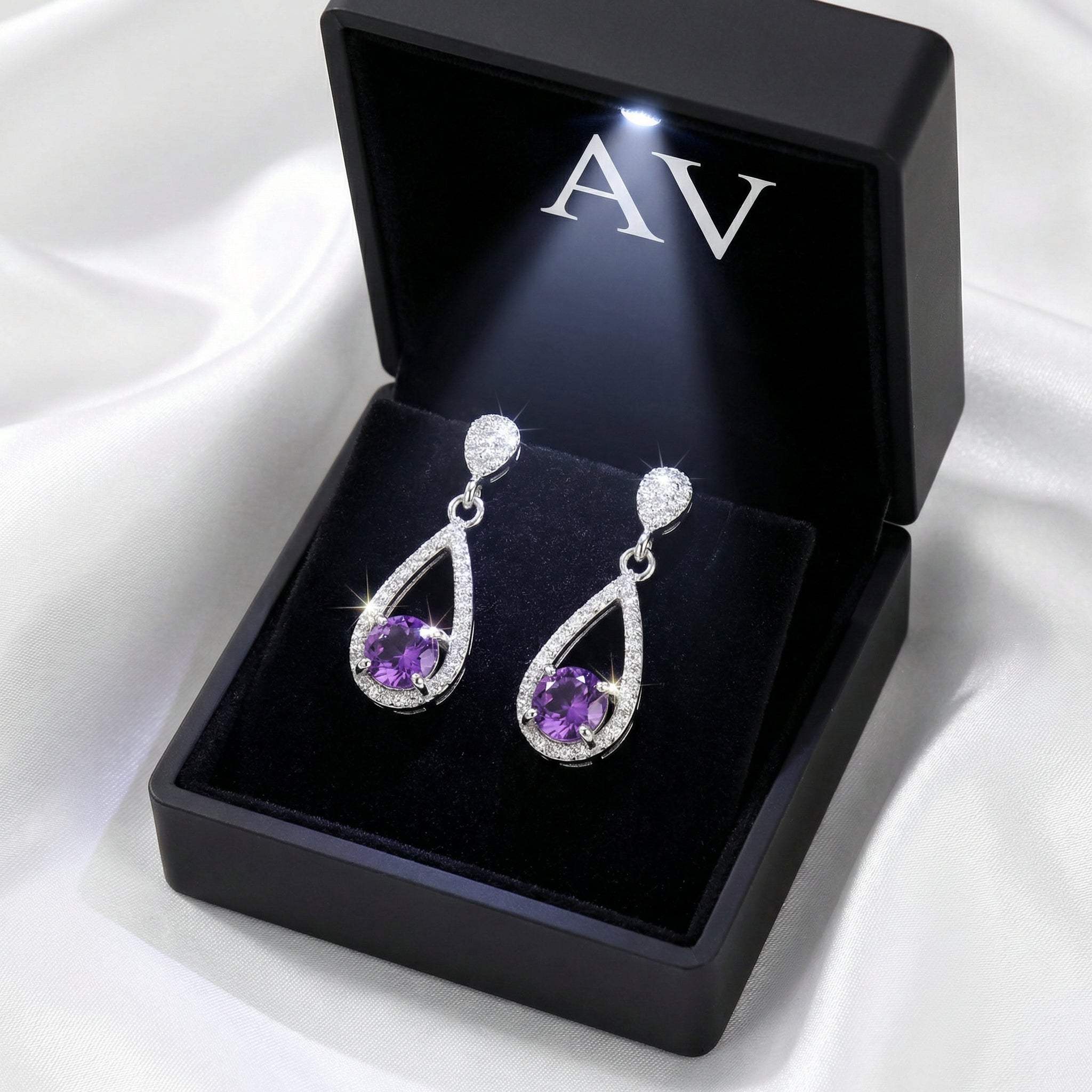 Sterling silver simulated amethyst drop earrings inside a black LED-lit jewelry presentation box.