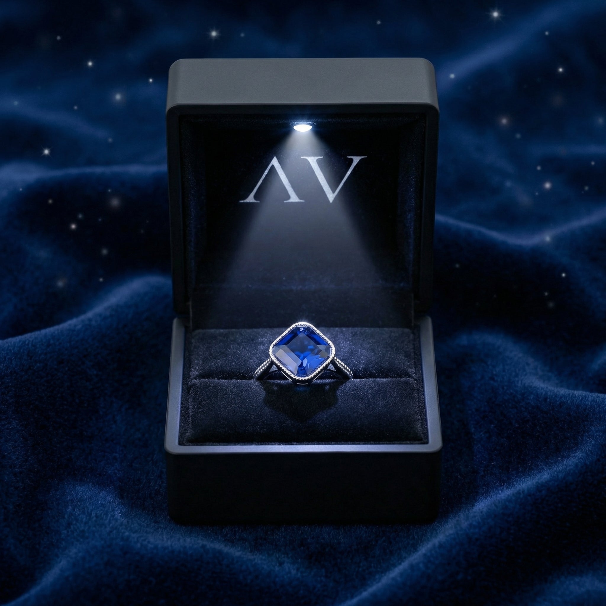 Blue simulated sapphire sterling silver ring inside a premium black LED-lighted jewelry gift box.