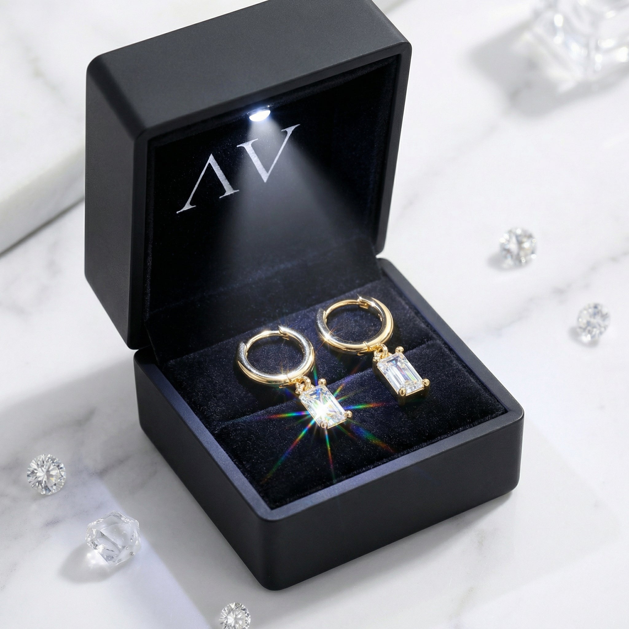 18K gold vermeil emerald cut drop earrings inside a black LED-lit jewelry presentation box.