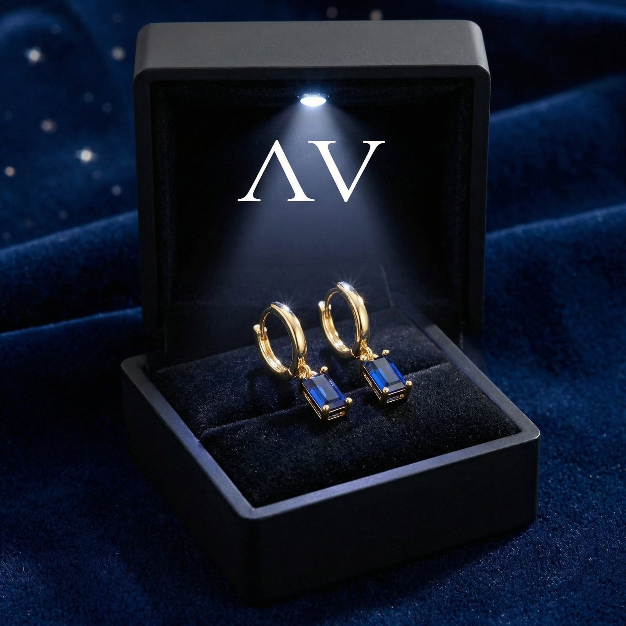 Gold vermeil blue sapphire hoop earrings presented in a black lighted jewelry box with the AV logo.