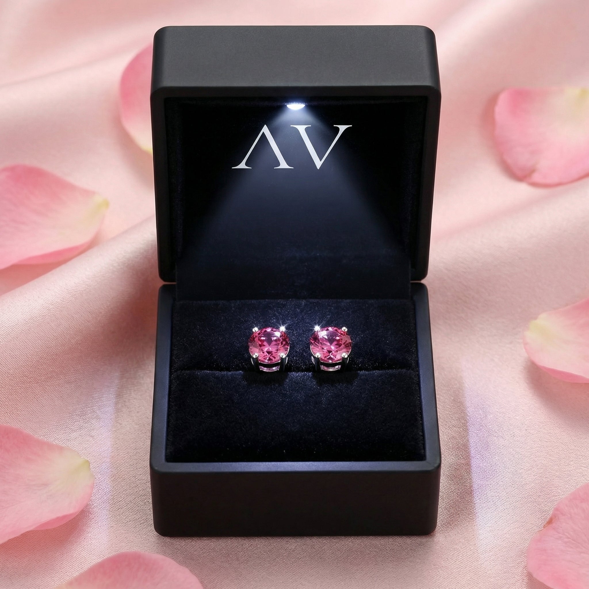 Simulated pink tourmaline sterling silver stud earrings in a black LED-lit jewelry presentation box.
