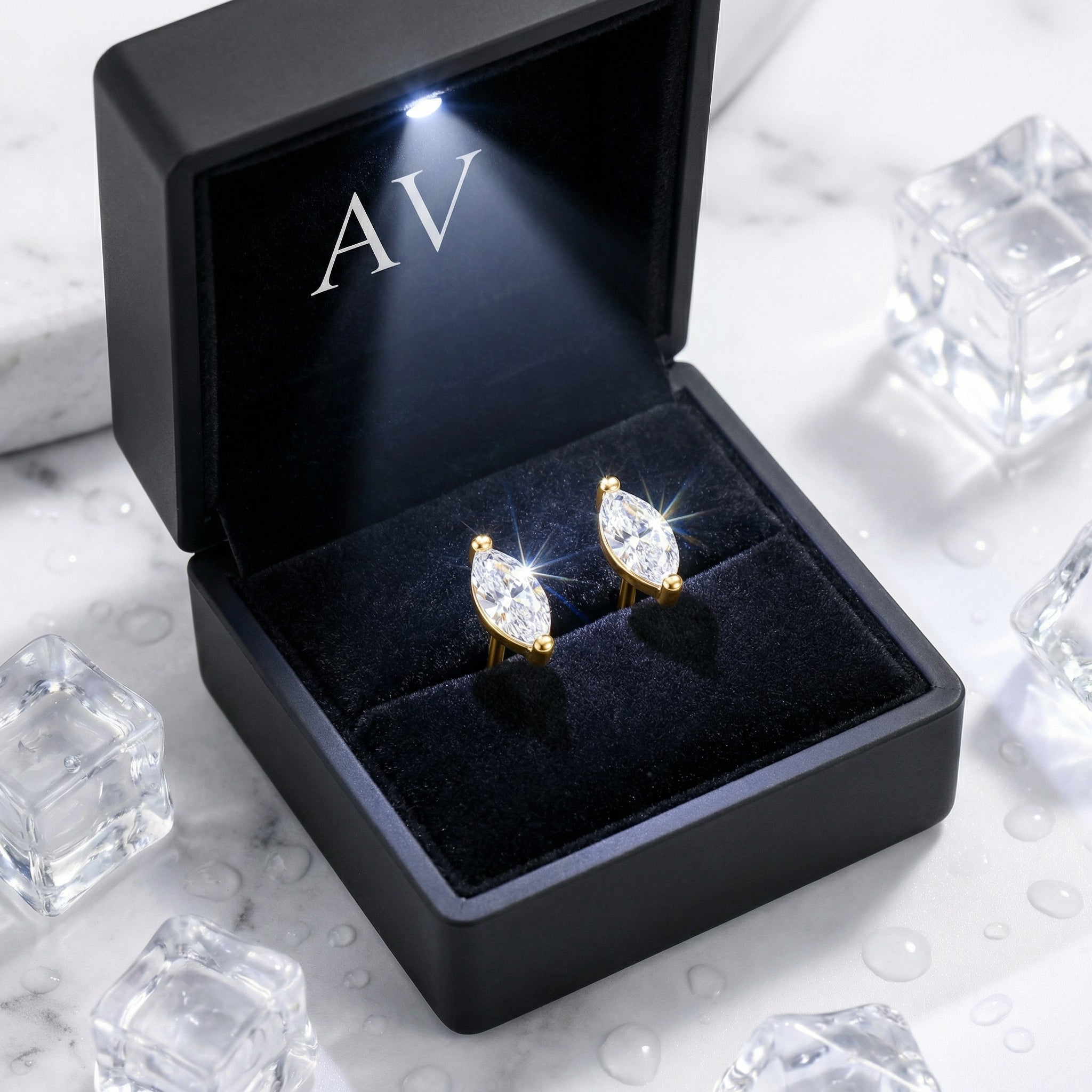 Marquise-cut simulated diamond stud earrings in 18K gold vermeil inside a black LED-lit jewelry box.