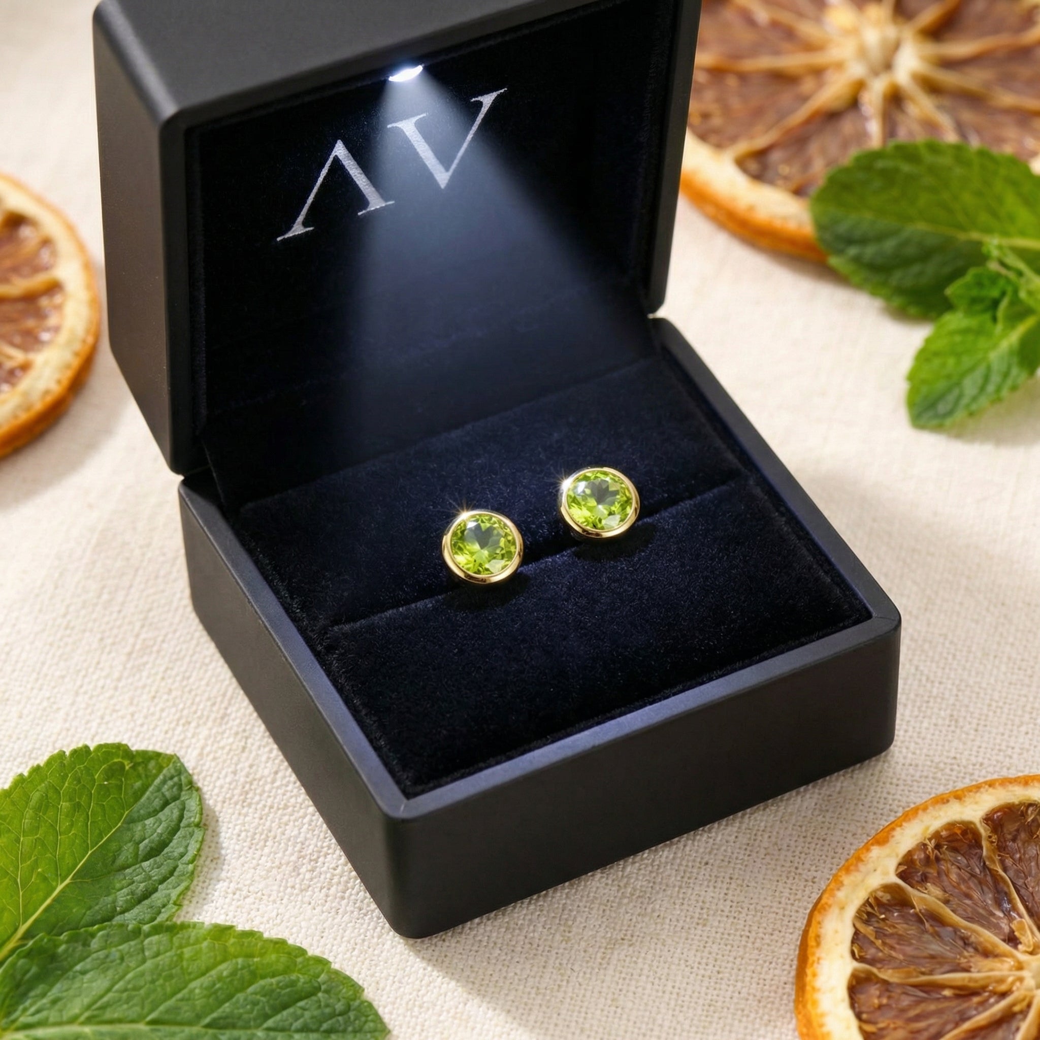 Simulated peridot stud earrings in 18K gold vermeil inside a premium black LED-lighted jewelry box.