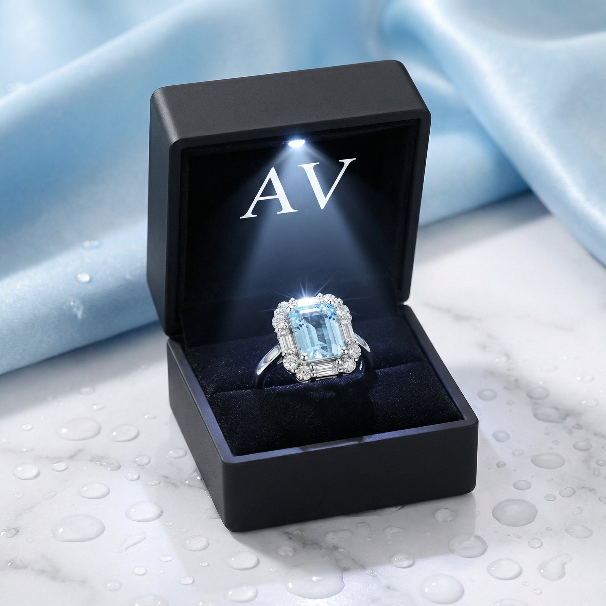 The Linnea simulated aquamarine halo ring in sterling silver presented in a black LED-lit jewelry gift box.