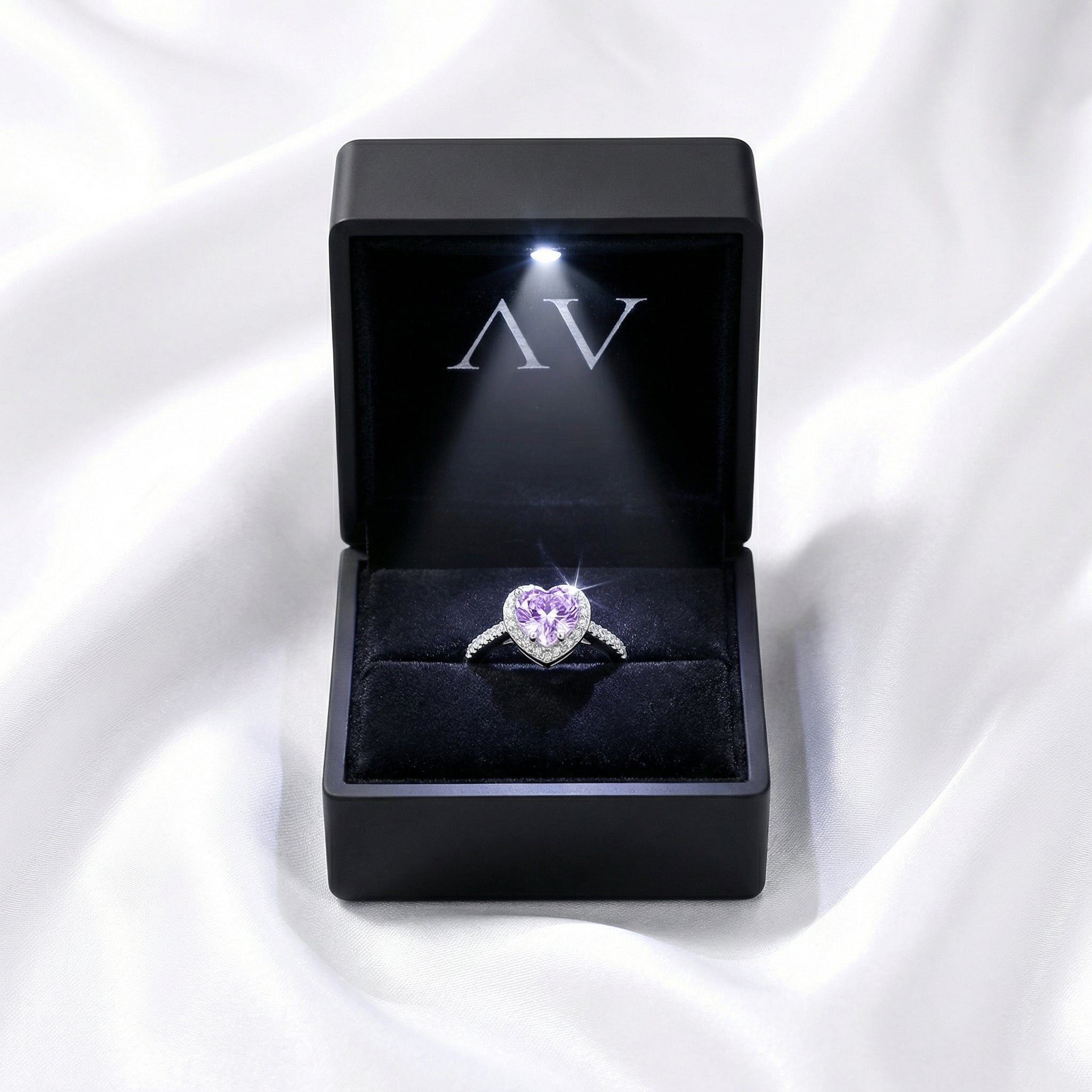 Heart-cut simulated amethyst S925 sterling silver ring inside a black LED-lit jewelry box.
