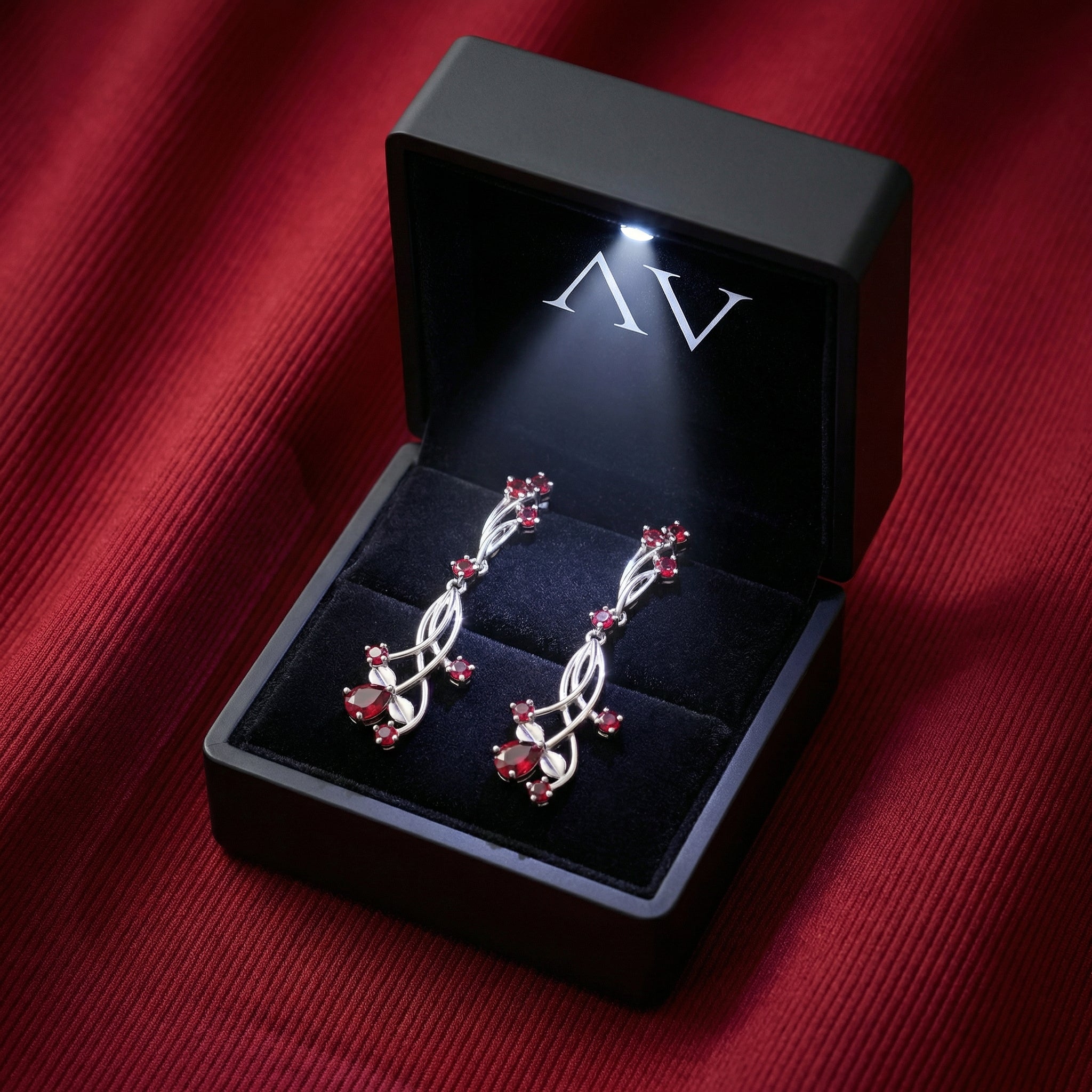 Sterling silver simulated ruby drop earrings presented in a black LED-lit jewelry gift box.