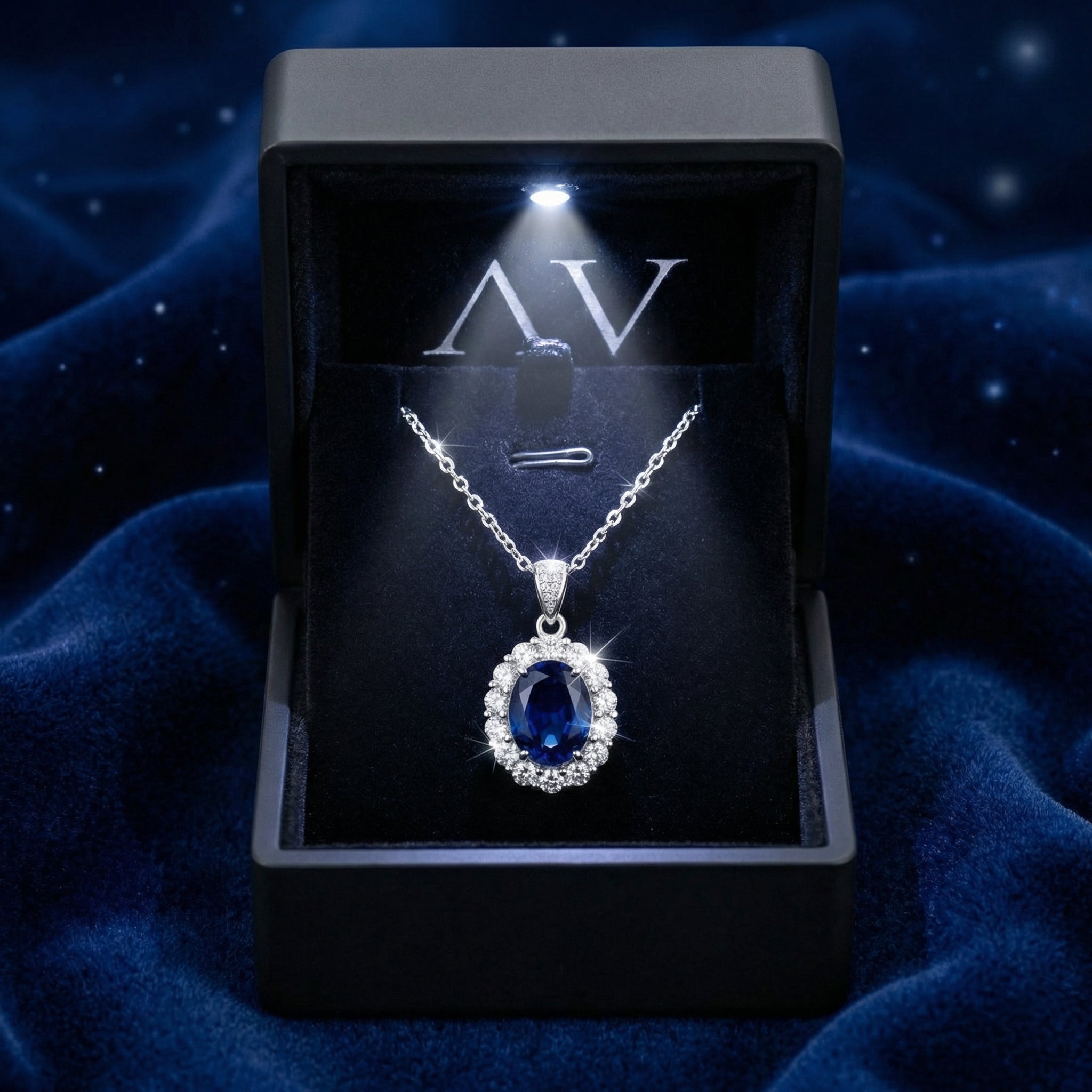 Serenara Halo sapphire necklace inside a premium lighted black jewelry box on a blue velvet surface.