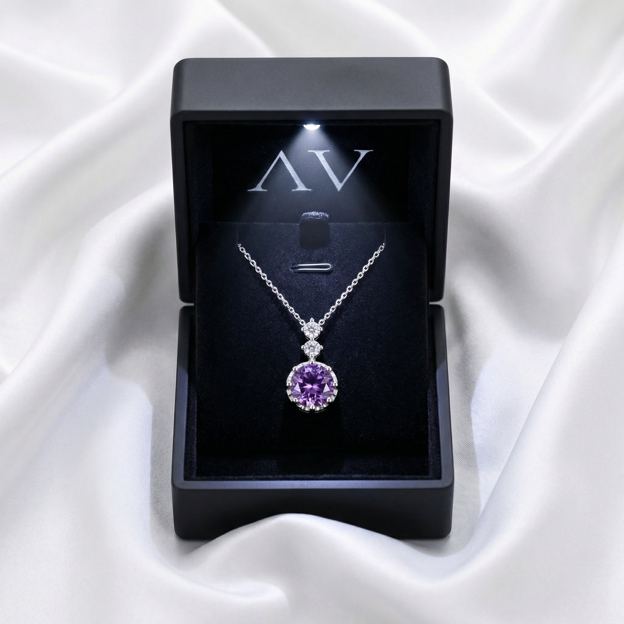 Sterling silver purple amethyst necklace in a lighted black jewelry gift box on white silk.